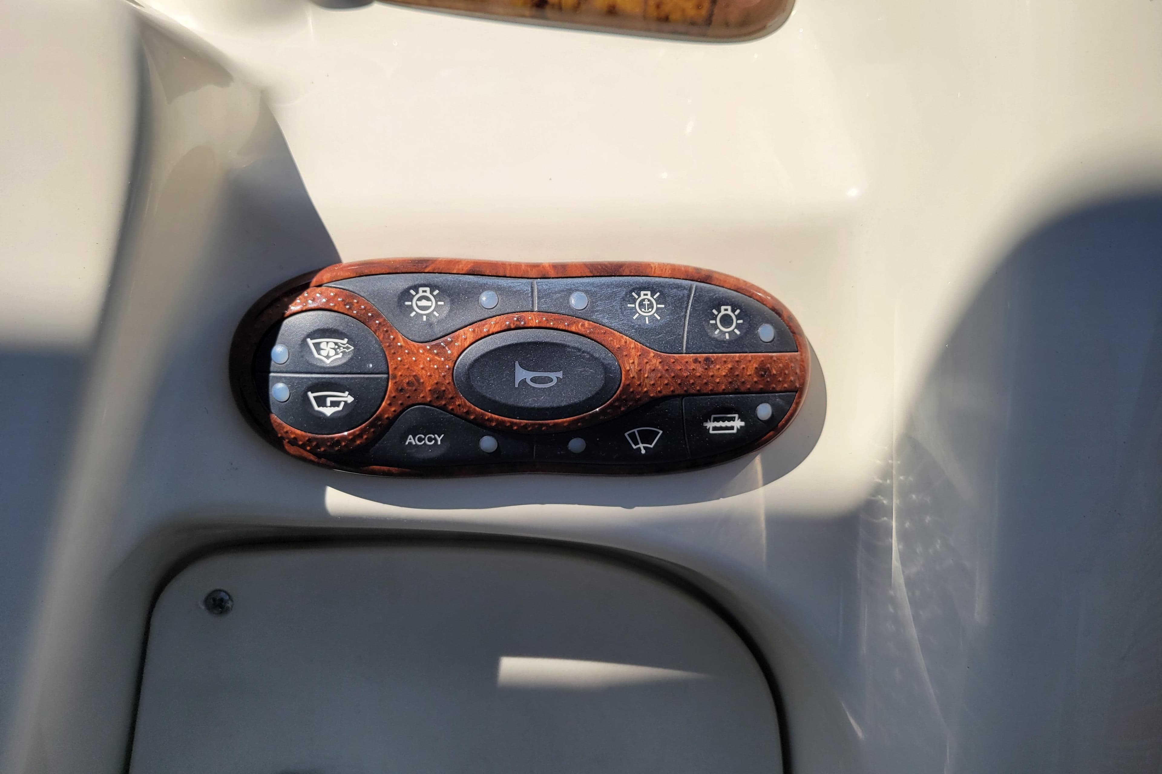 Control panel of a 2004 Sea Ray 240 Sundancer boat with various switches.