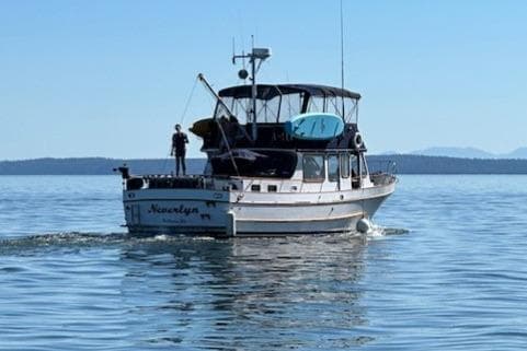 1972 DeFever 38 Passagemaker cruising on calm waters under clear blue skies.