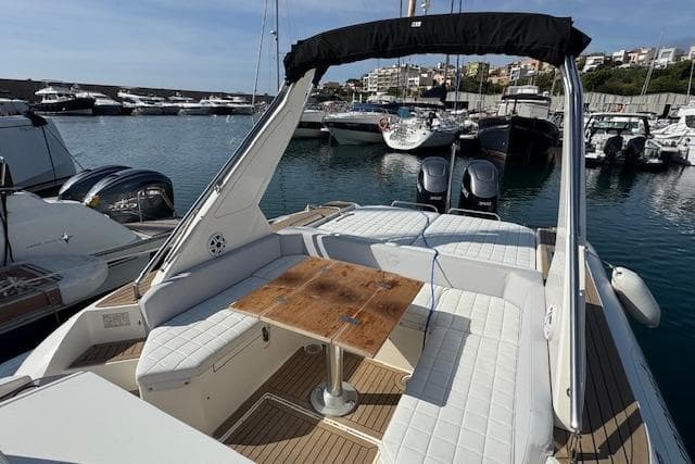 2023 Capelli Tempest 40 boat with spacious seating and wooden table in a marina.
