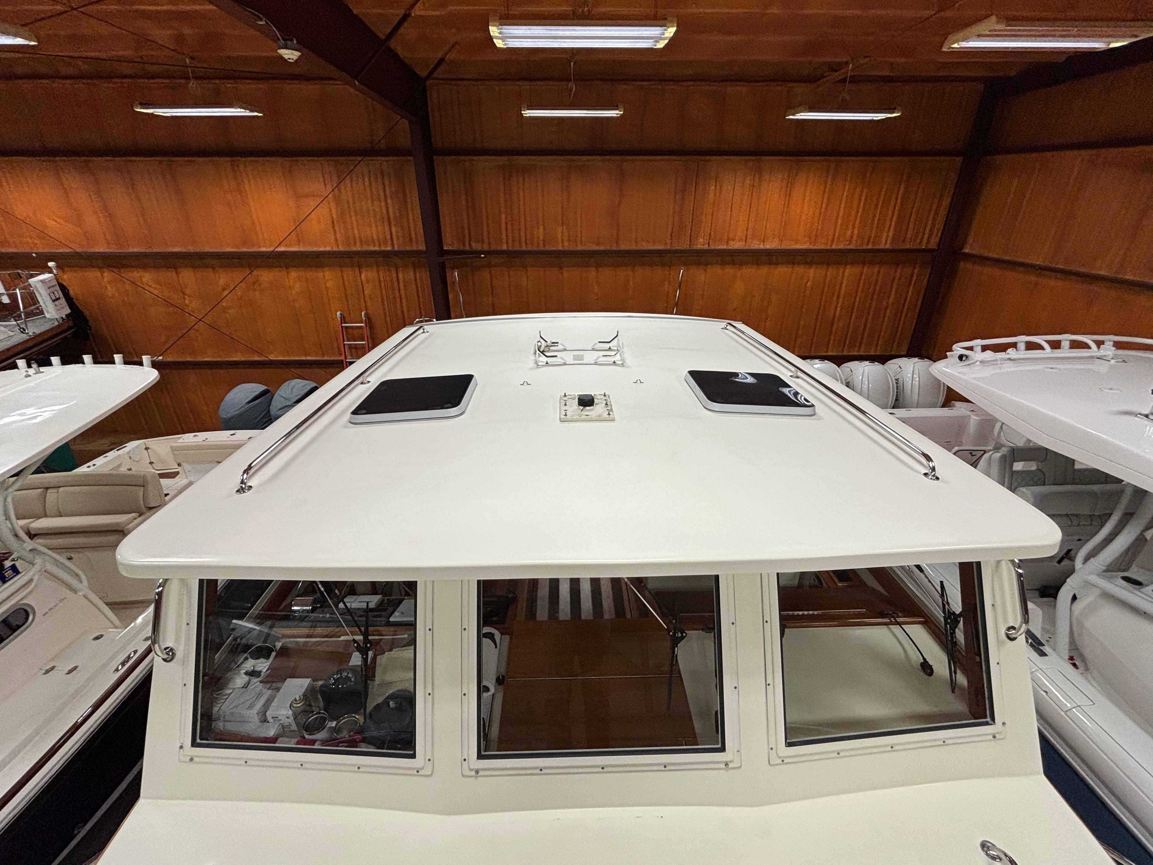 2006 Ellis Express boat in indoor storage, showcasing roof and windows.