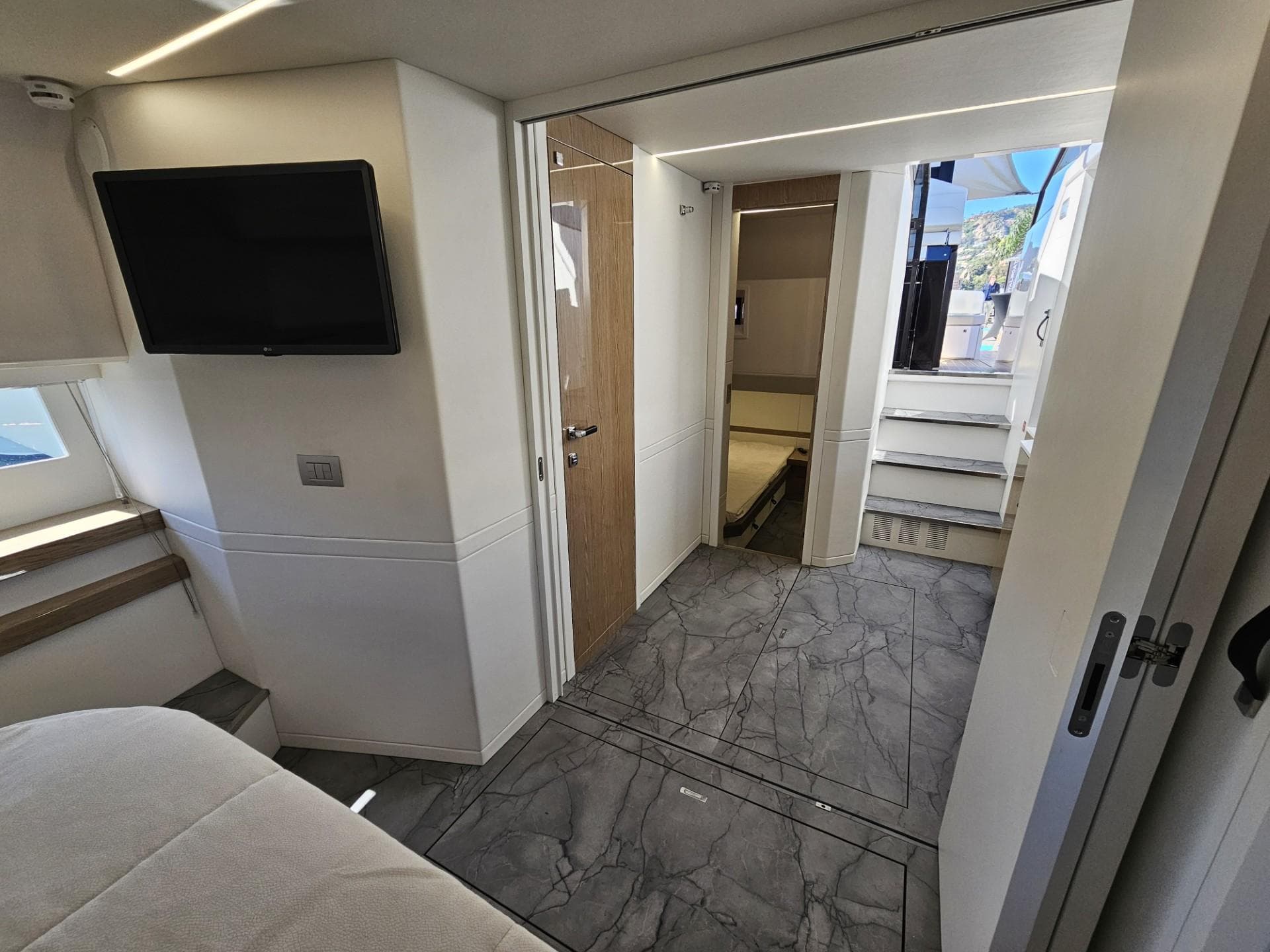 2024 Rio Yachts Daytona 50 interior with modern design, featuring a TV and sleek flooring.