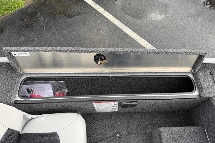 2026 Crestliner 1600 Storm boat storage compartment open, revealing interior space.
