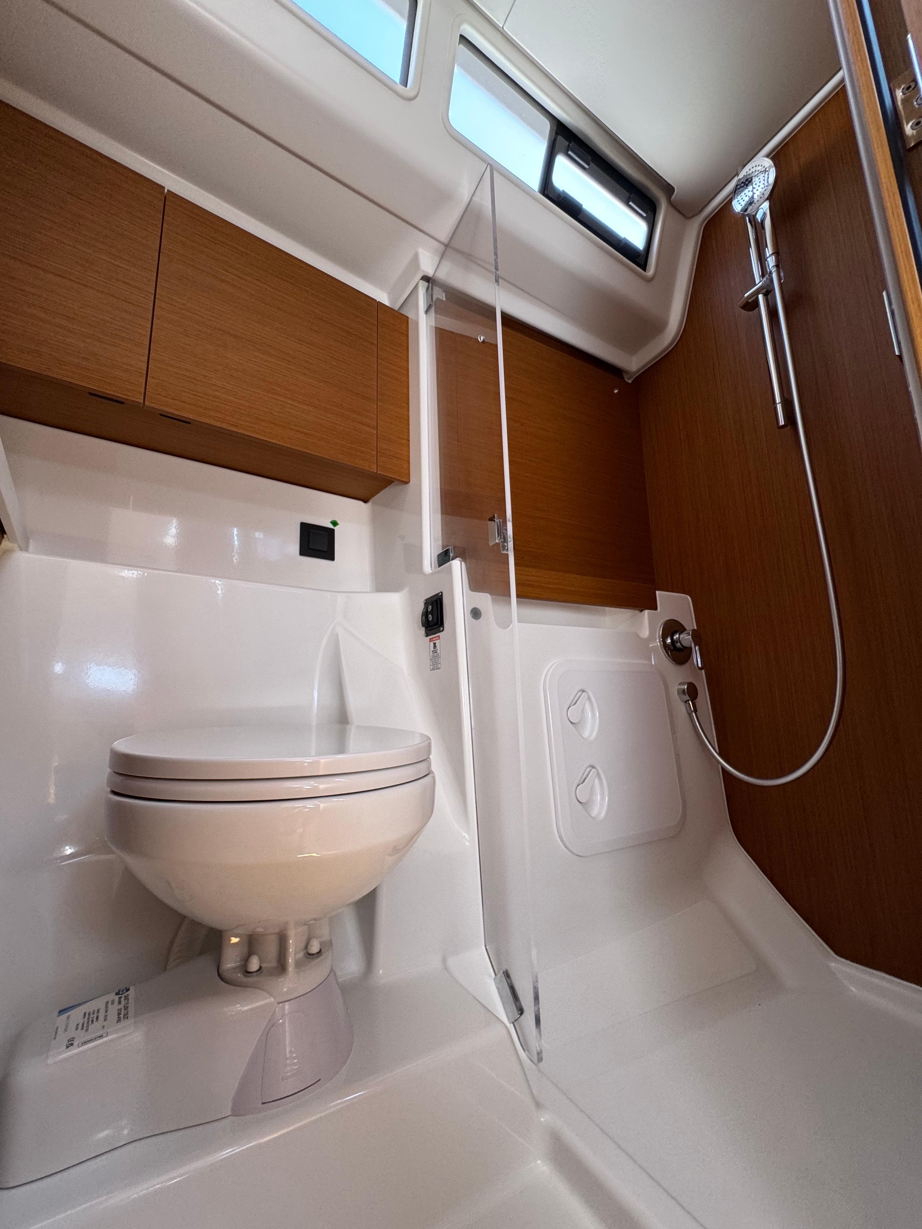 Modern bathroom in 2024 Beneteau First 44 yacht with shower and toilet.