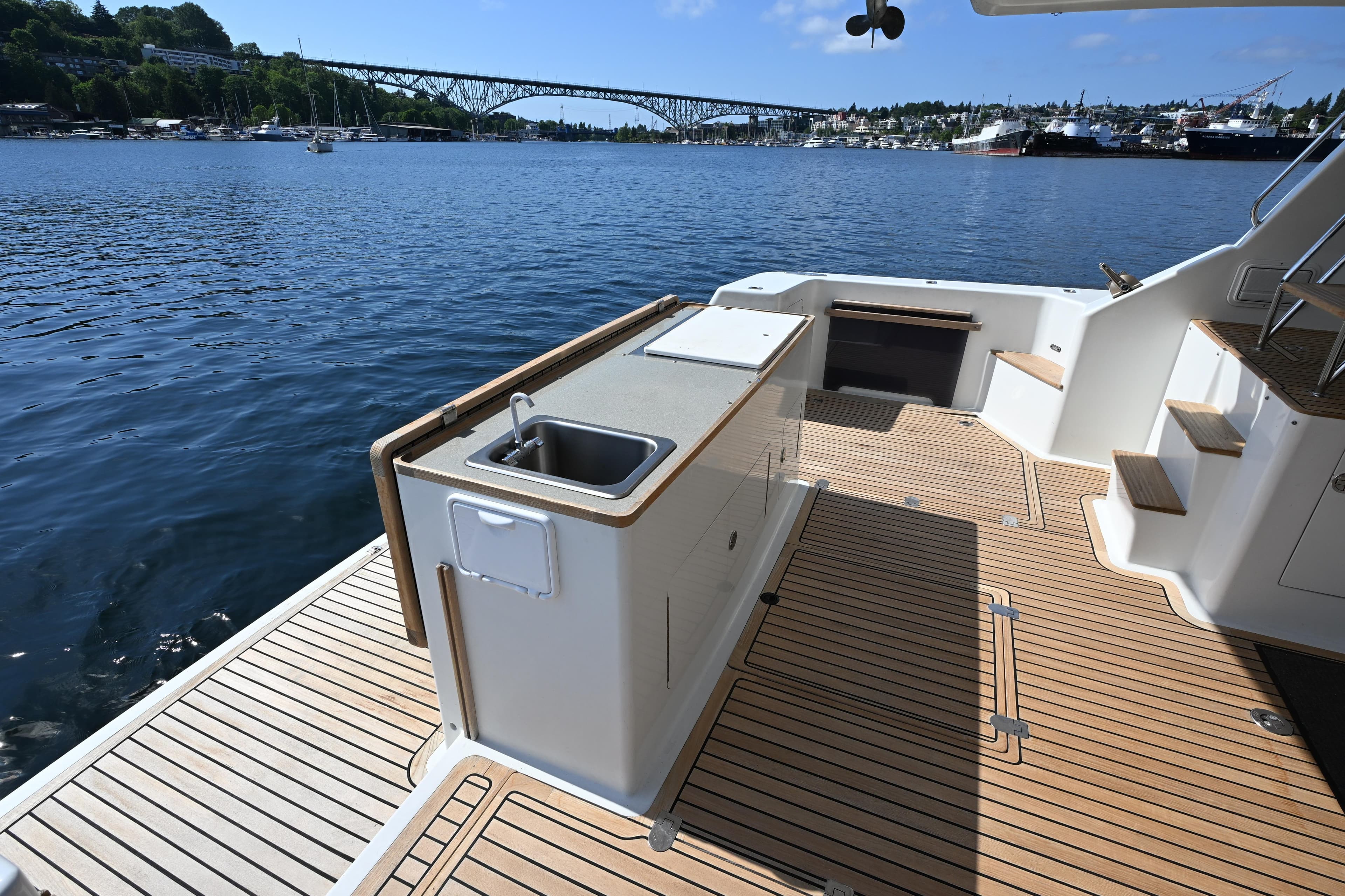 Deck view of 2002 Roger Hill Power Cat 41.4, featuring outdoor sink and scenic waterfront.