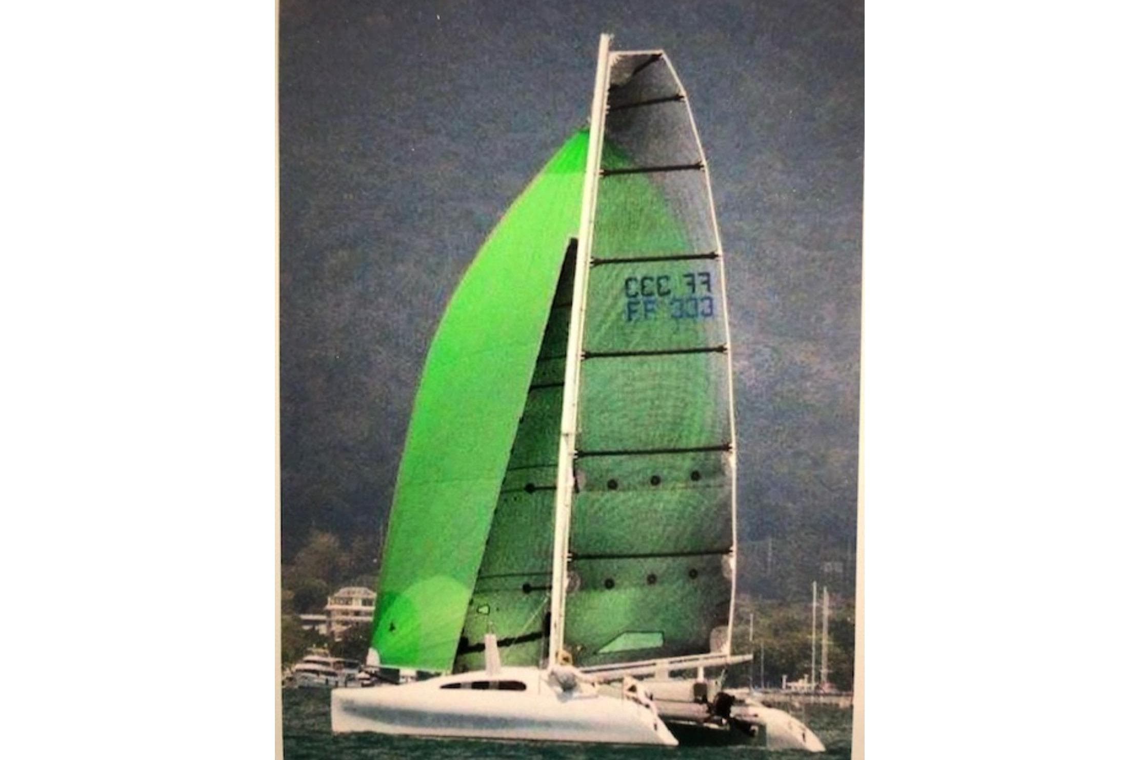 Sailing catamaran Prescott Firefly 850, 2016 model, with vibrant green sails on the water.