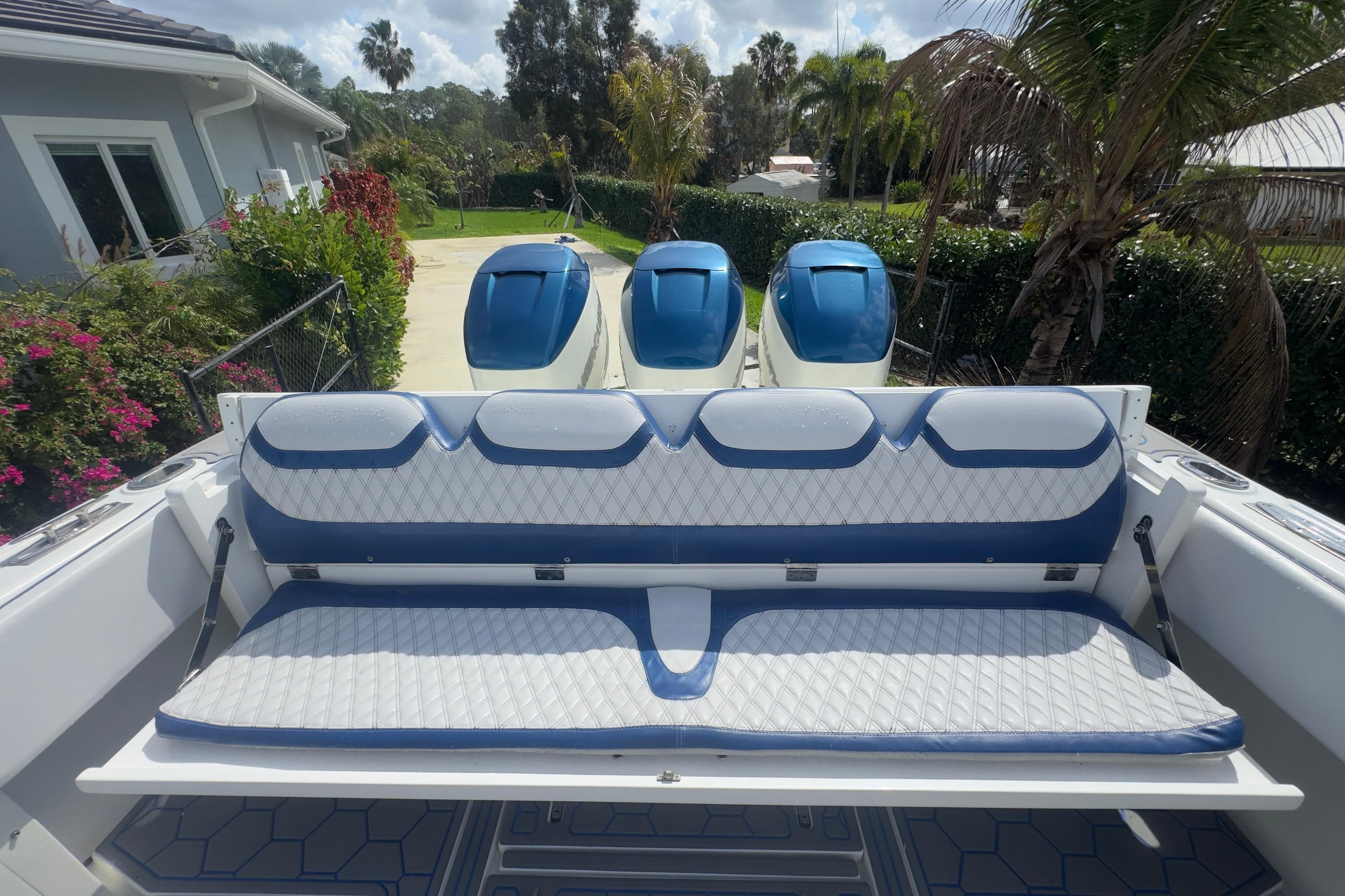 2007 Intrepid 370 Center Console boat with blue and white seating and triple engines.