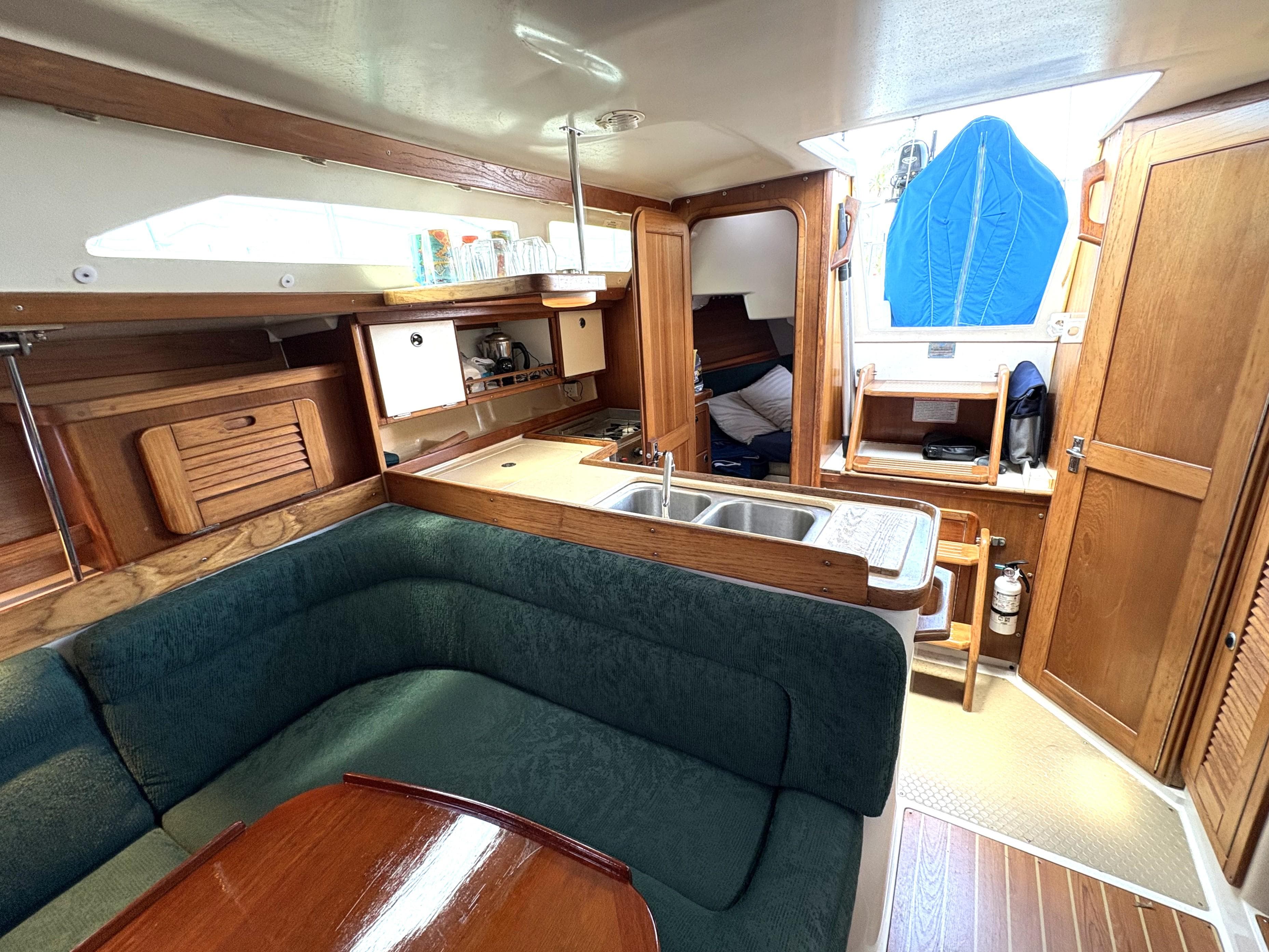 Interior of 1998 Catalina 34 MkII sailboat with cozy seating and compact kitchen area.