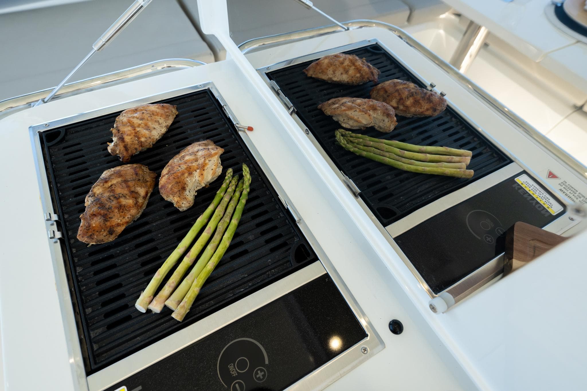 Grilled chicken and asparagus on Aquila 42 Yacht's outdoor grill, 2023 model.