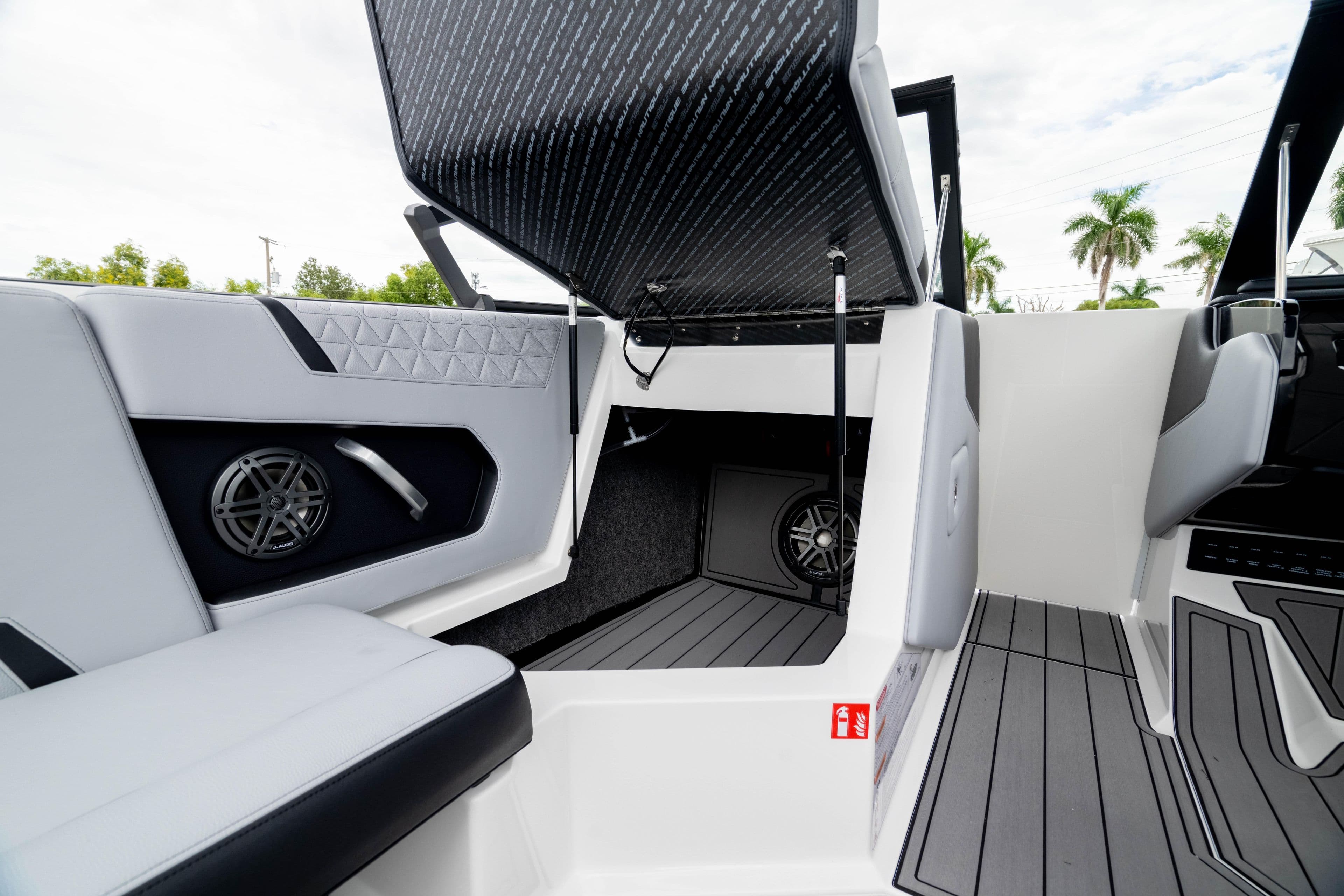 2026 Nautique Super Air Nautique GS22 interior with open storage, speakers, and sleek seating.
