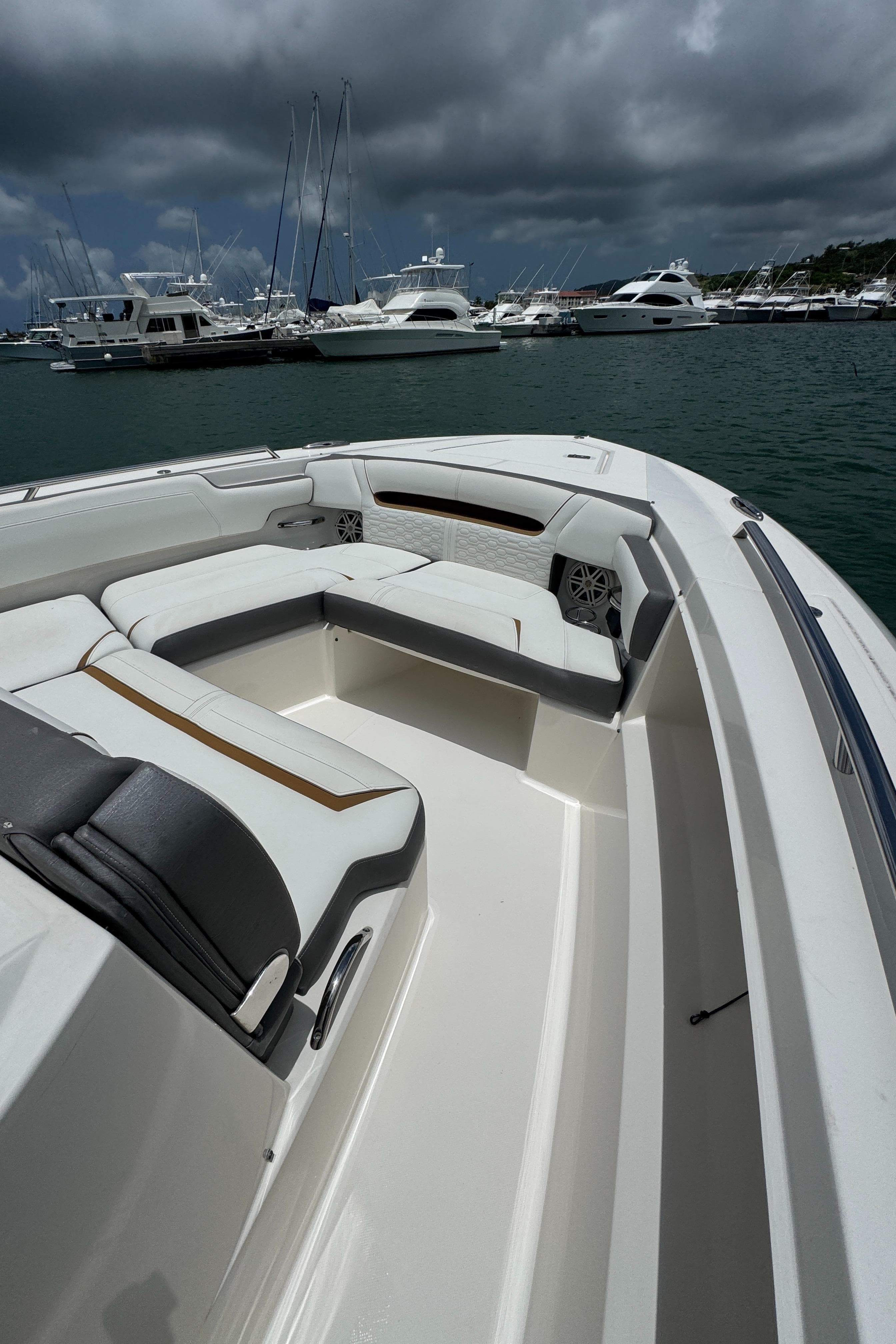 2020 Tiara Sport 34 LS boat interior with luxurious seating, docked in a marina under cloudy skies.