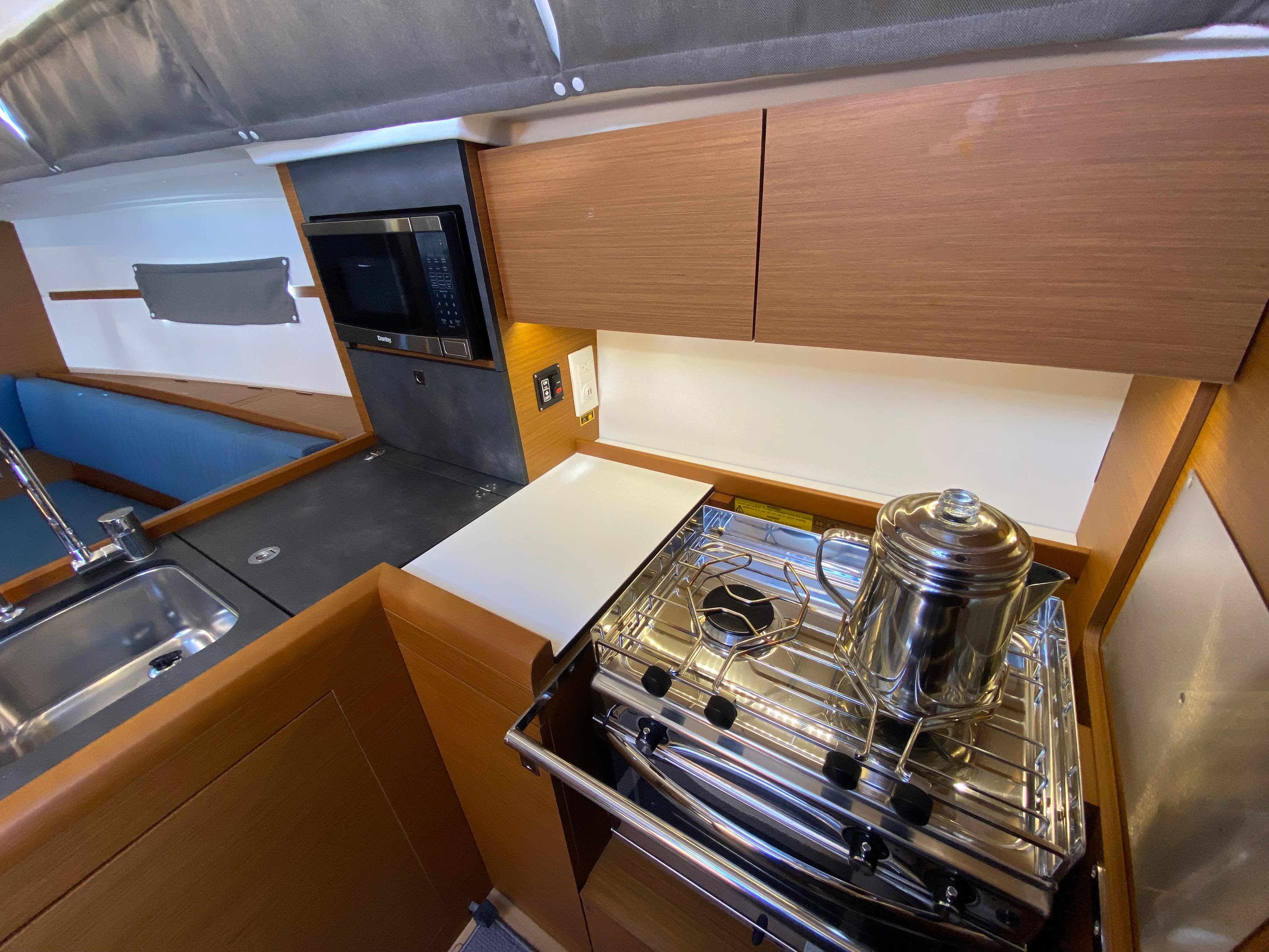 2023 Jeanneau Sun Odyssey 349 yacht kitchen with stove, sink, and microwave.