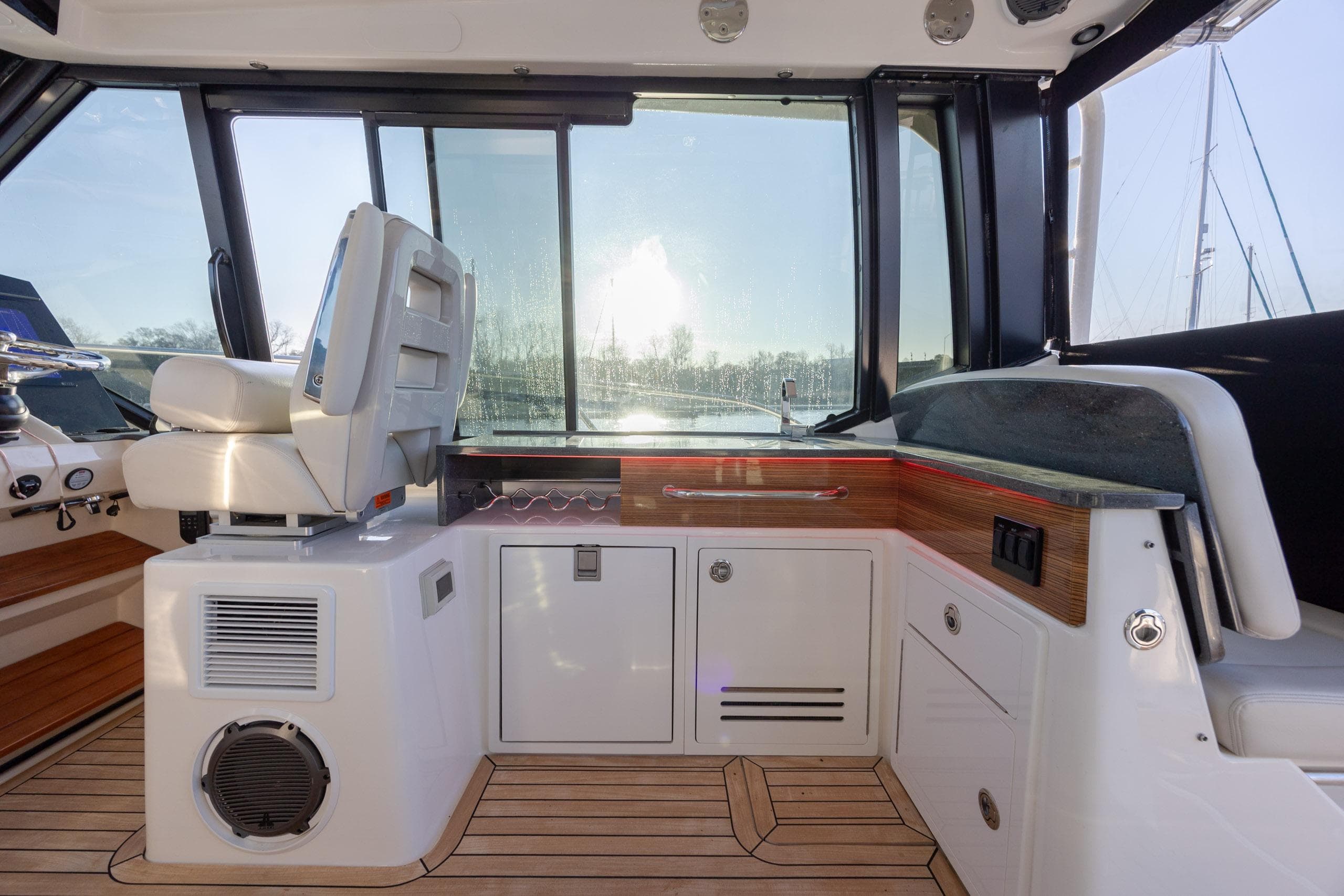 2021 Boston Whaler 405 Conquest interior with helm seat and wooden cabinetry.