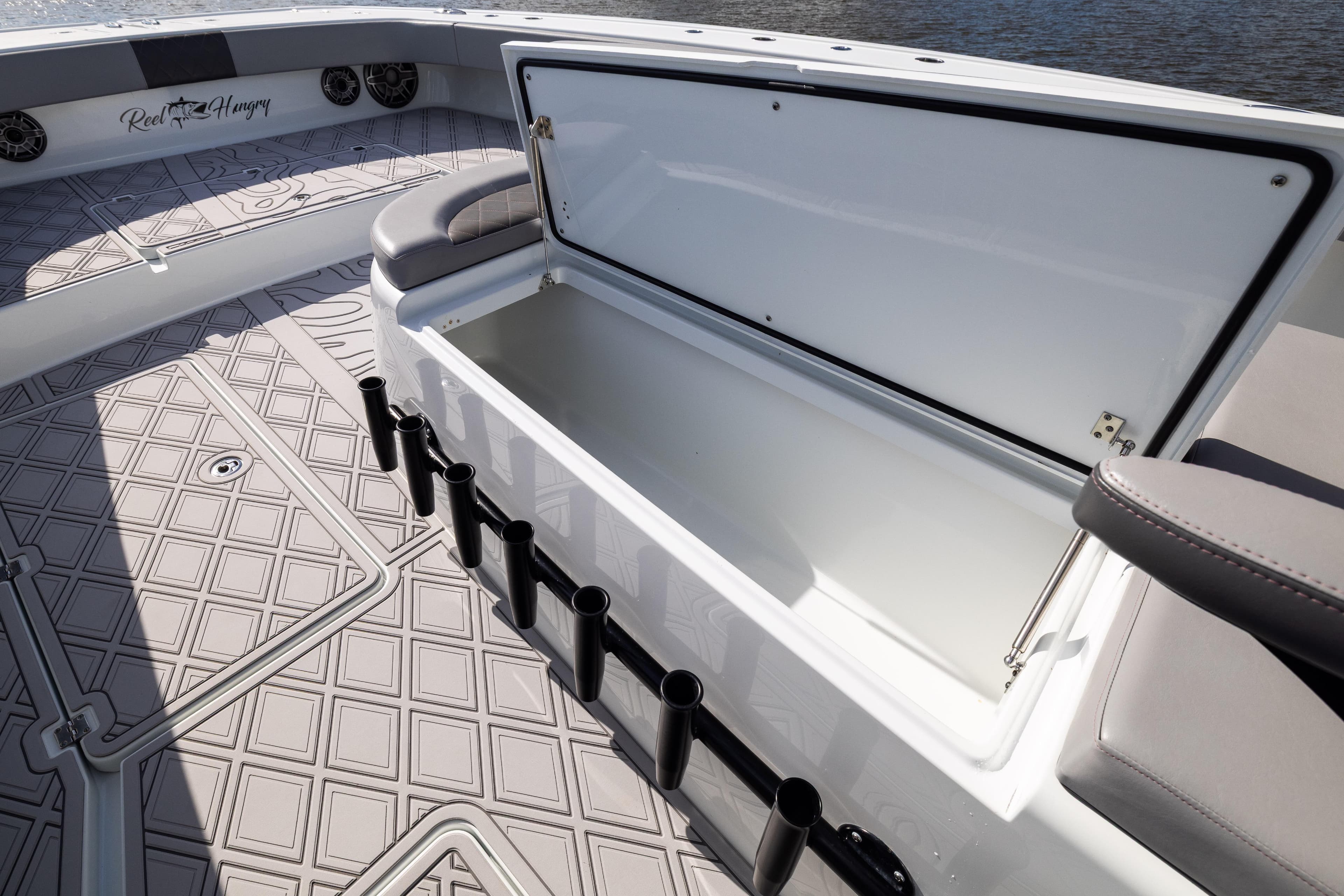 2023 Freeman 47 boat with open storage compartment and rod holders on deck.