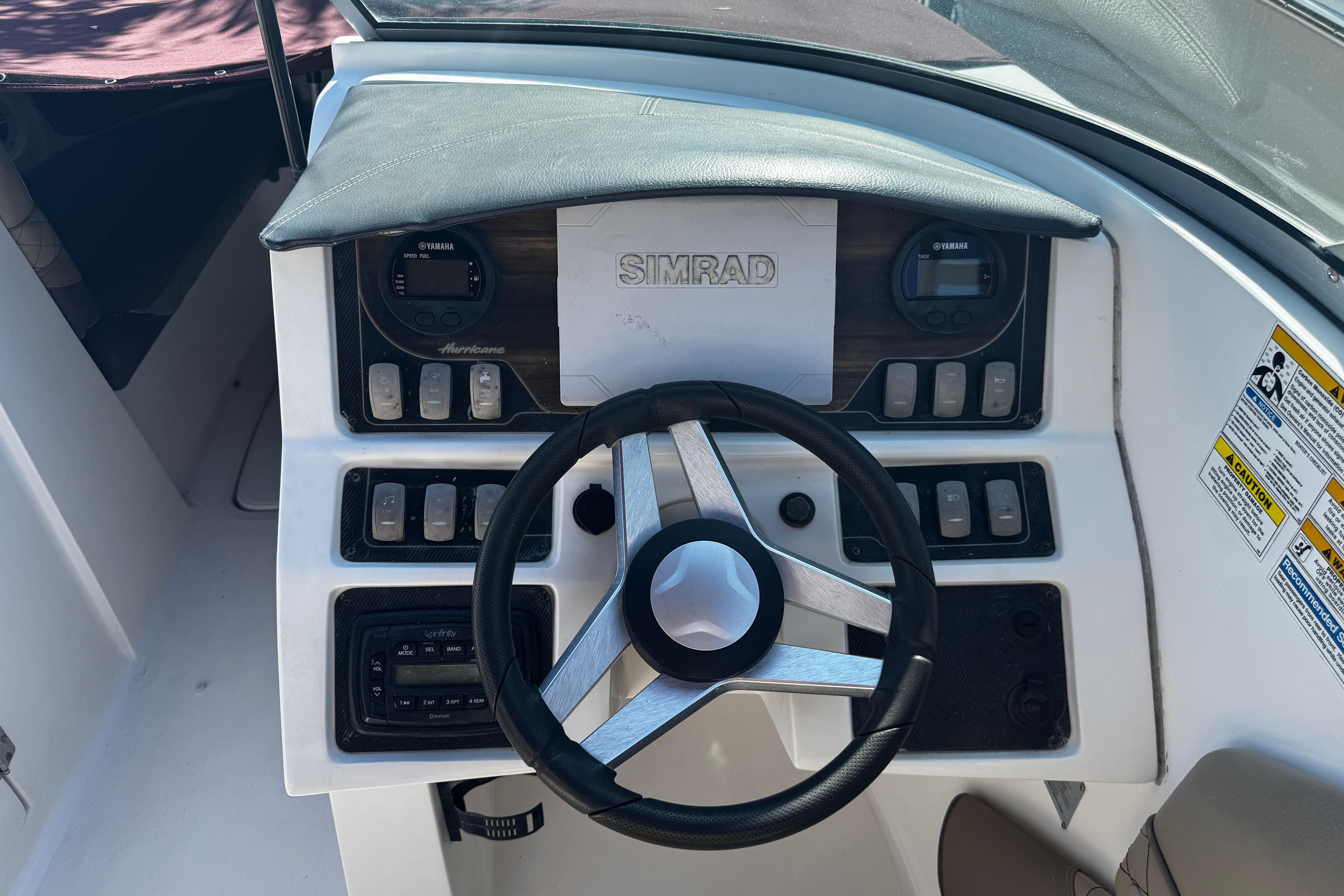 2019 Hurricane SunDeck 2690 OB boat dashboard with steering wheel and control panel.
