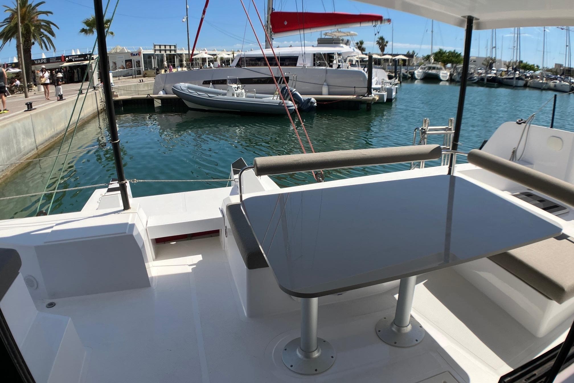 Modern NEEL 43 trimaran cockpit with table, docked at marina, 2024 model.