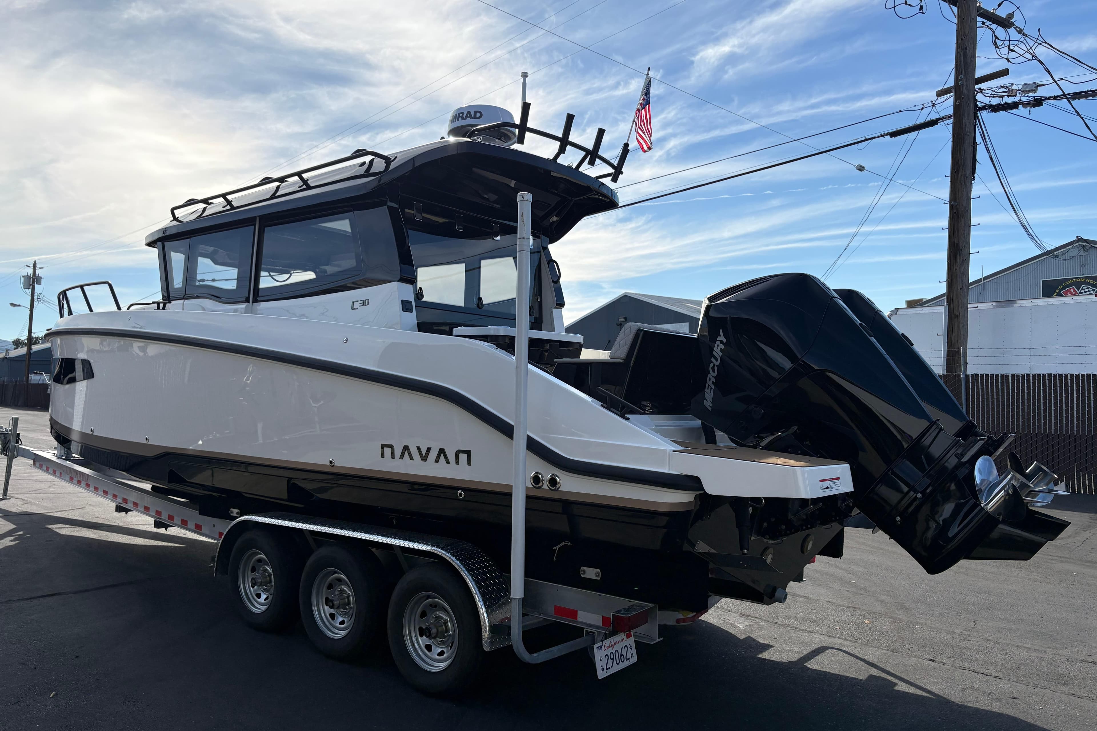 Navan C30 2026 boat on trailer with dual Mercury engines, parked outdoors.