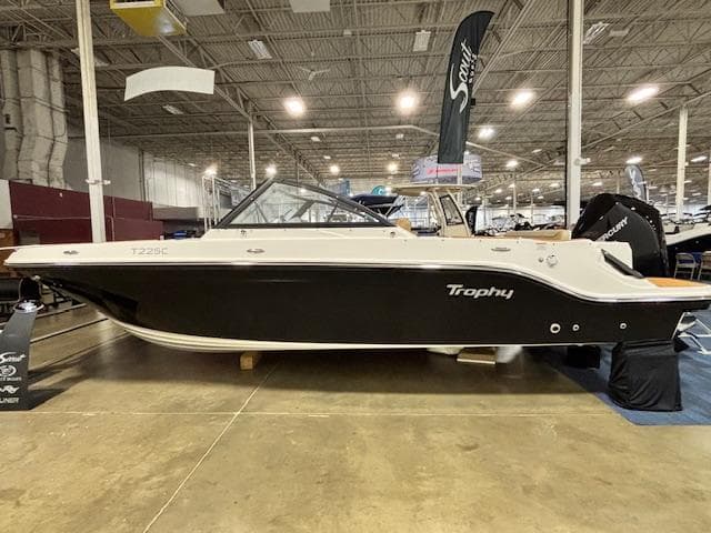 2025 Bayliner T22 SC boat displayed indoors, featuring sleek black and white design.