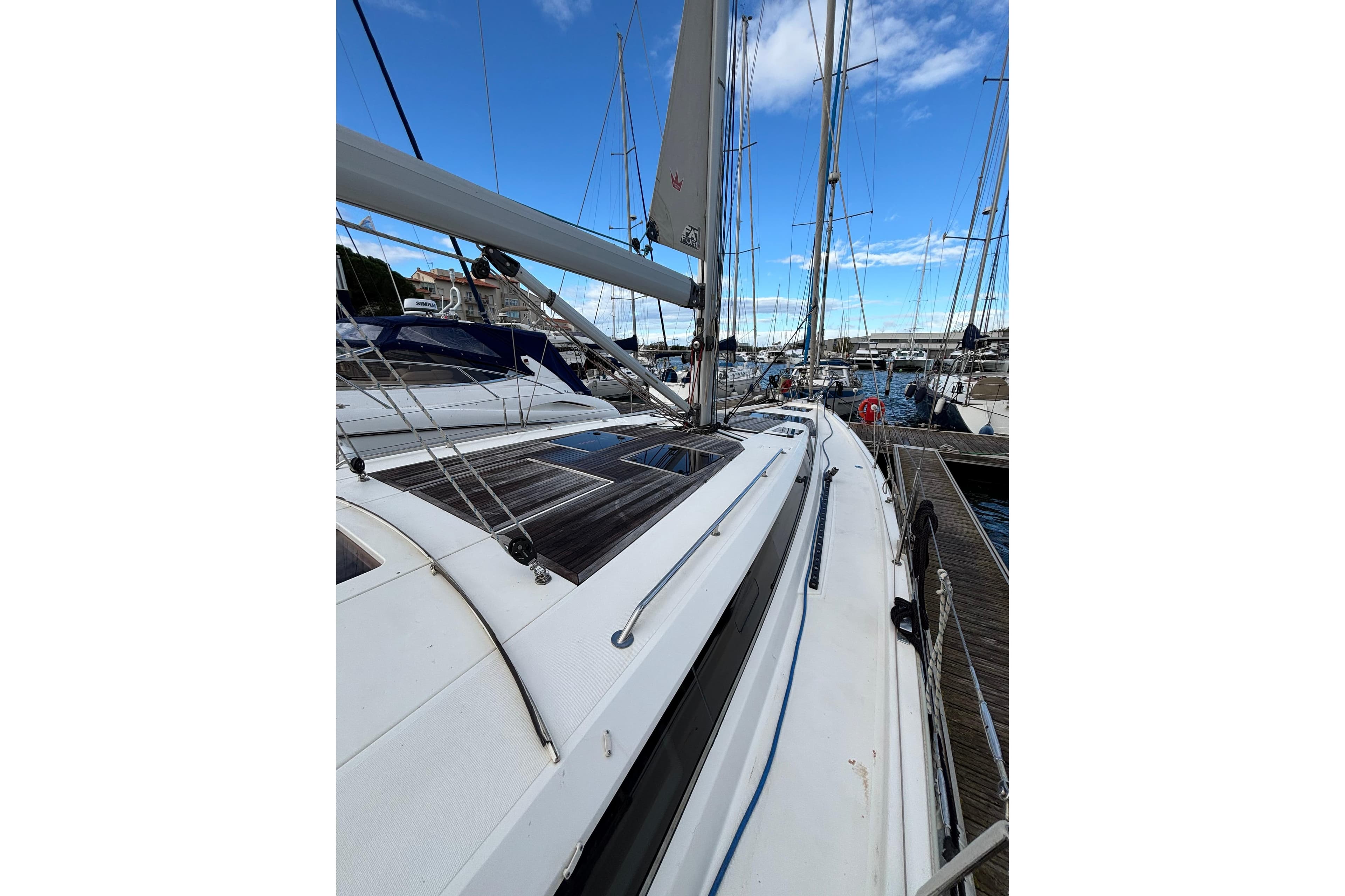 2019 Bavaria C45 sailboat docked at marina under clear blue sky.