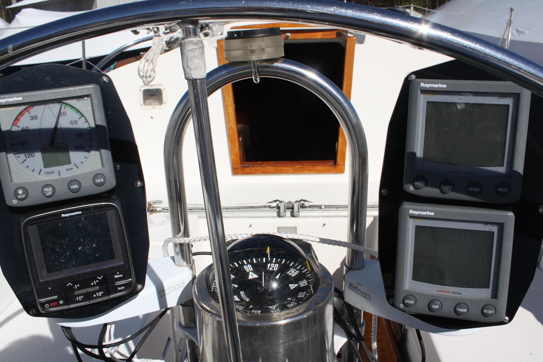 Cockpit of a 1976 C&C 38 sailboat with navigation instruments and compass.