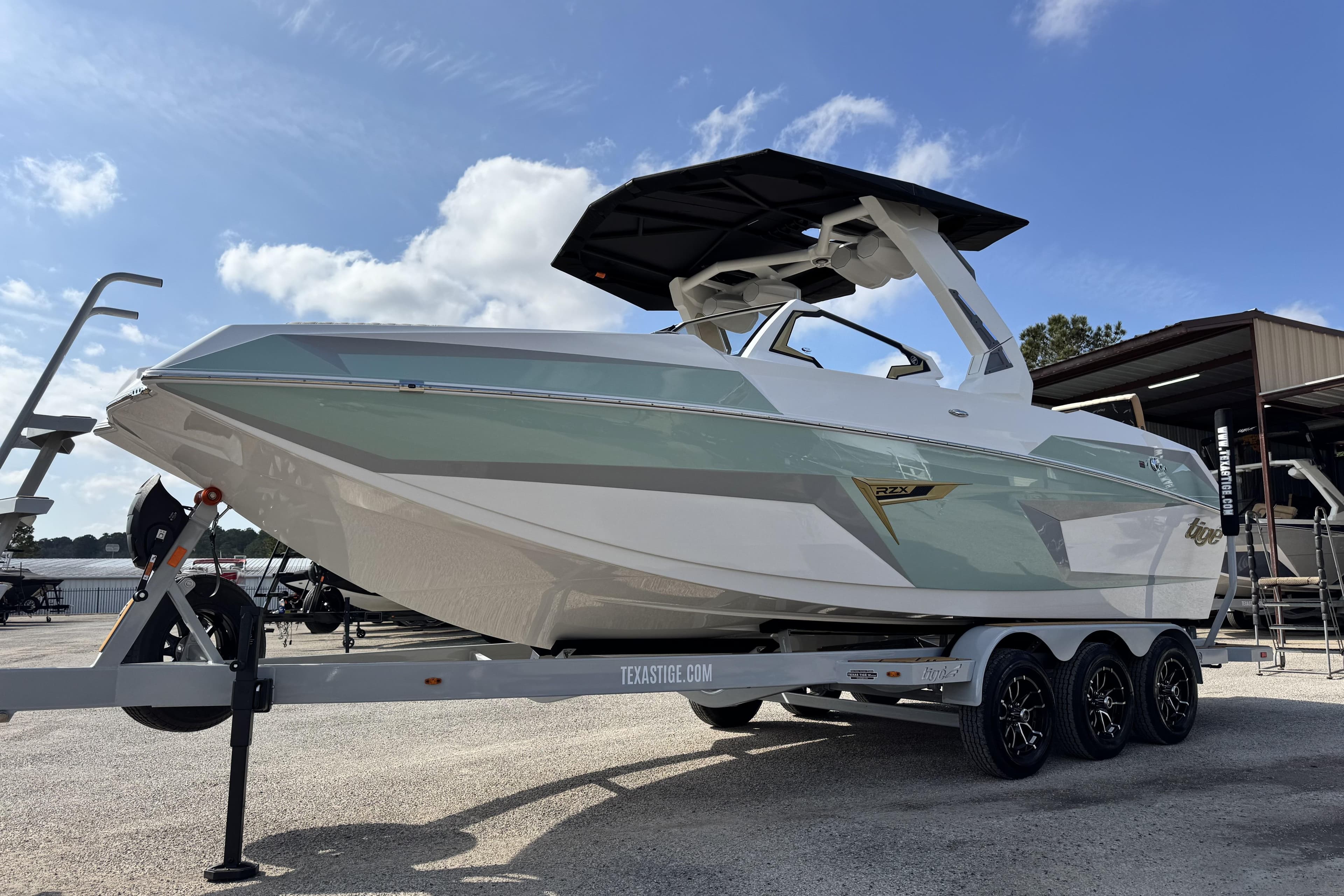 2026 Tigé 24RZX boat on trailer, sleek design, under clear blue sky.