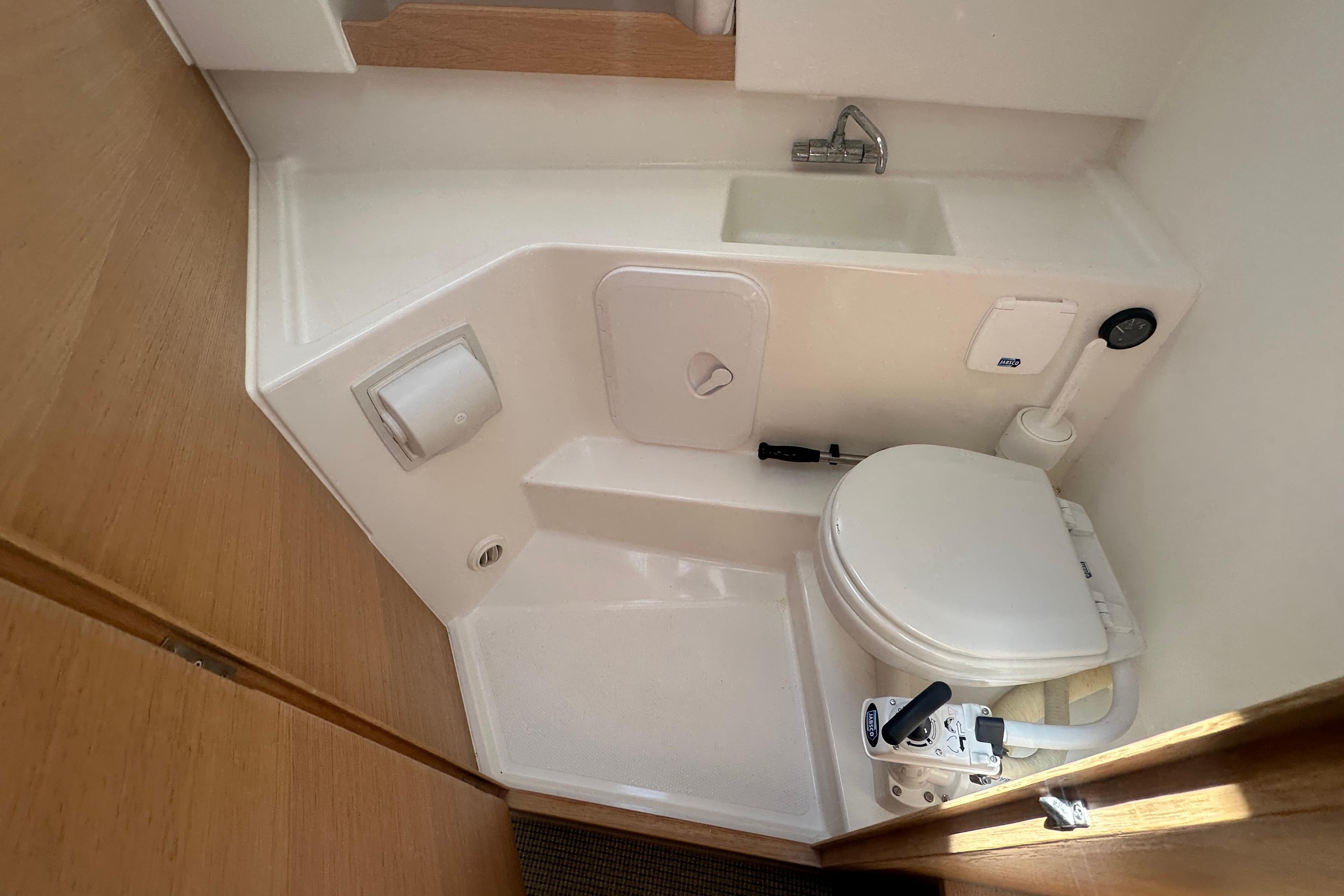 Compact bathroom in 2023 Nimbus Weekender 9 boat with toilet and sink.