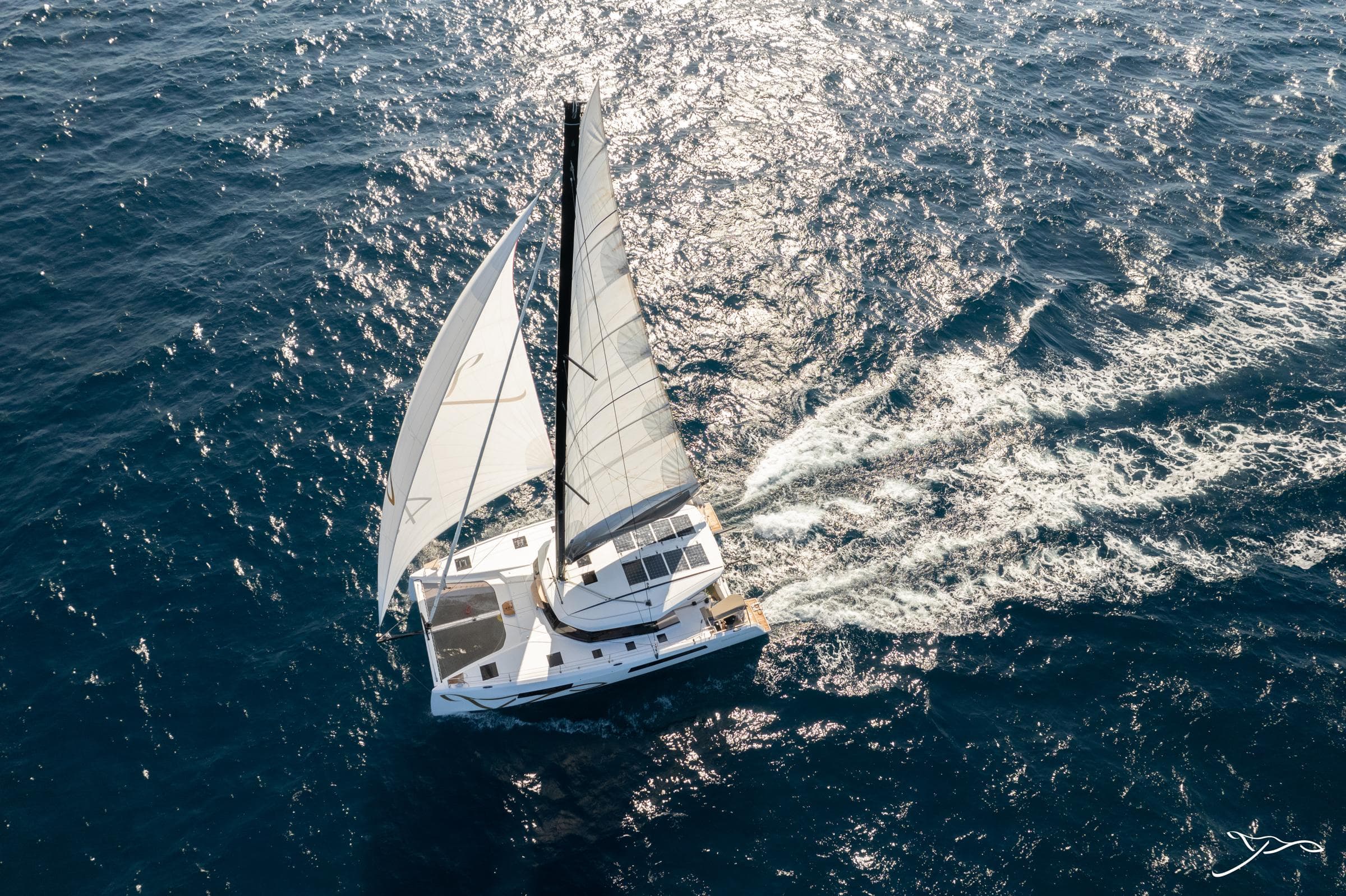 Aerial view of 2025 Nautitech 44 Open catamaran sailing on open sea.