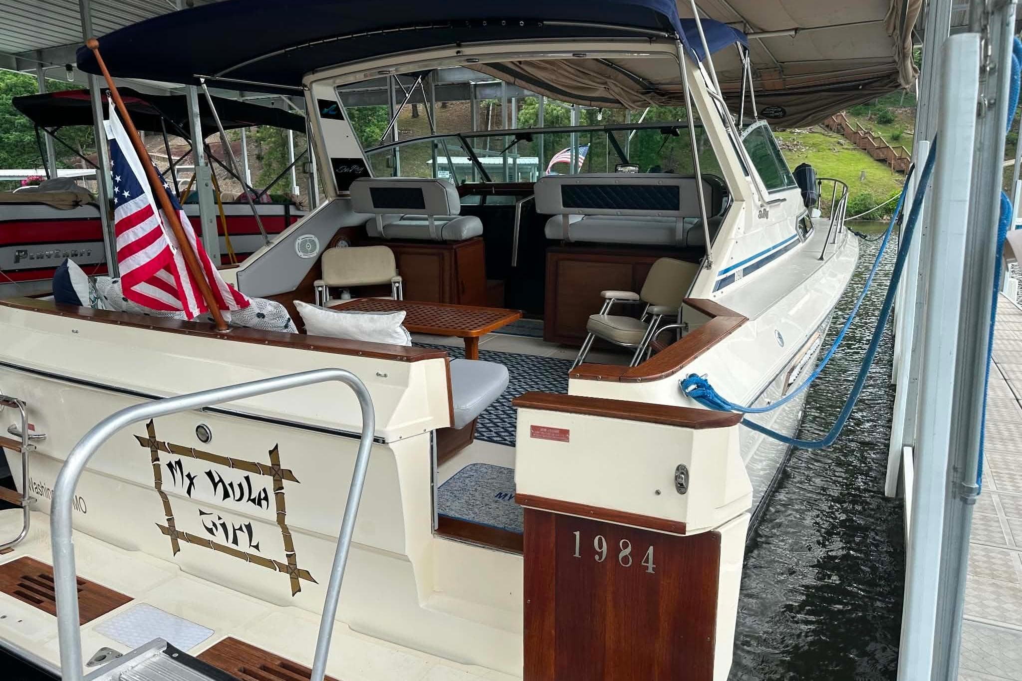 1988 Sea Ray 390 Express Cruiser docked, featuring spacious seating and American flag.