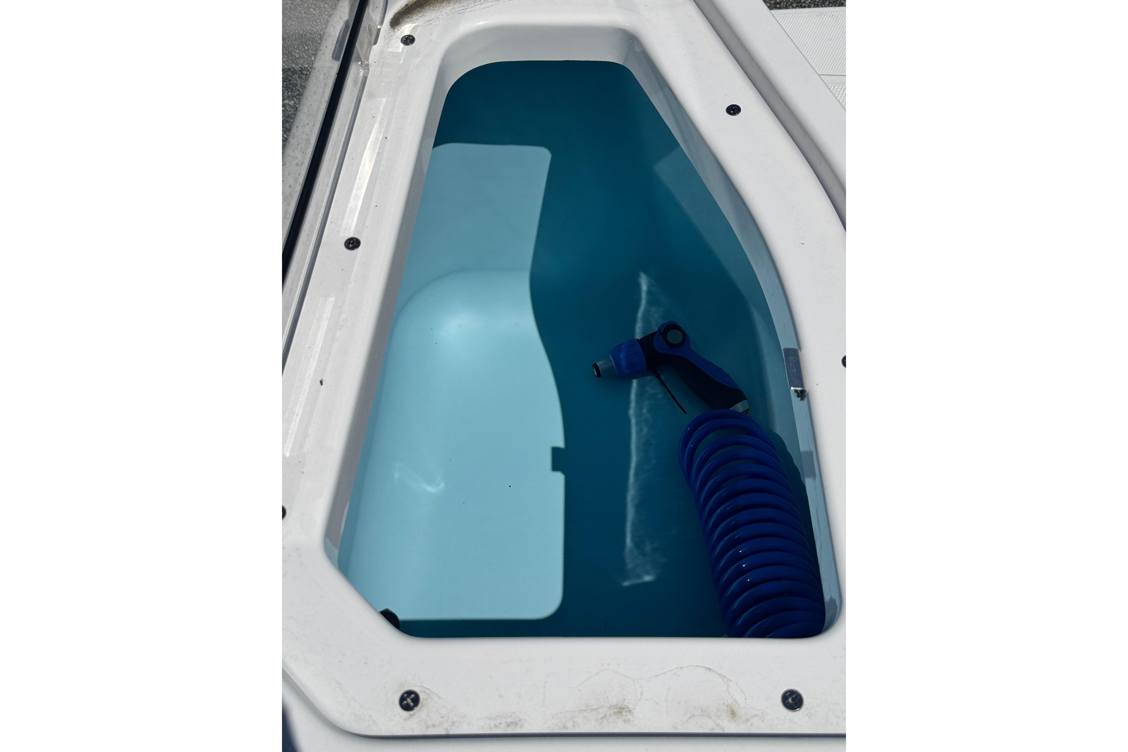Yamaha Boats 2026 255 FSH Sport E storage compartment with blue hose.