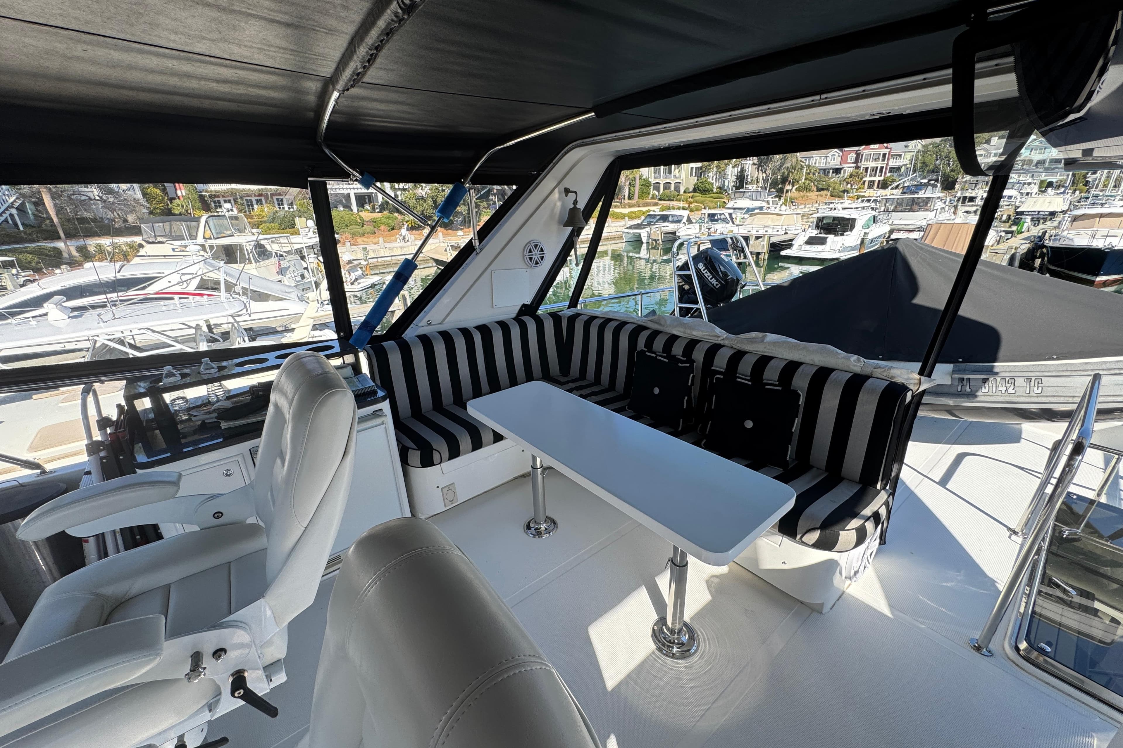 2003 Altima 55 Pilothouse interior with striped seating and marina view.