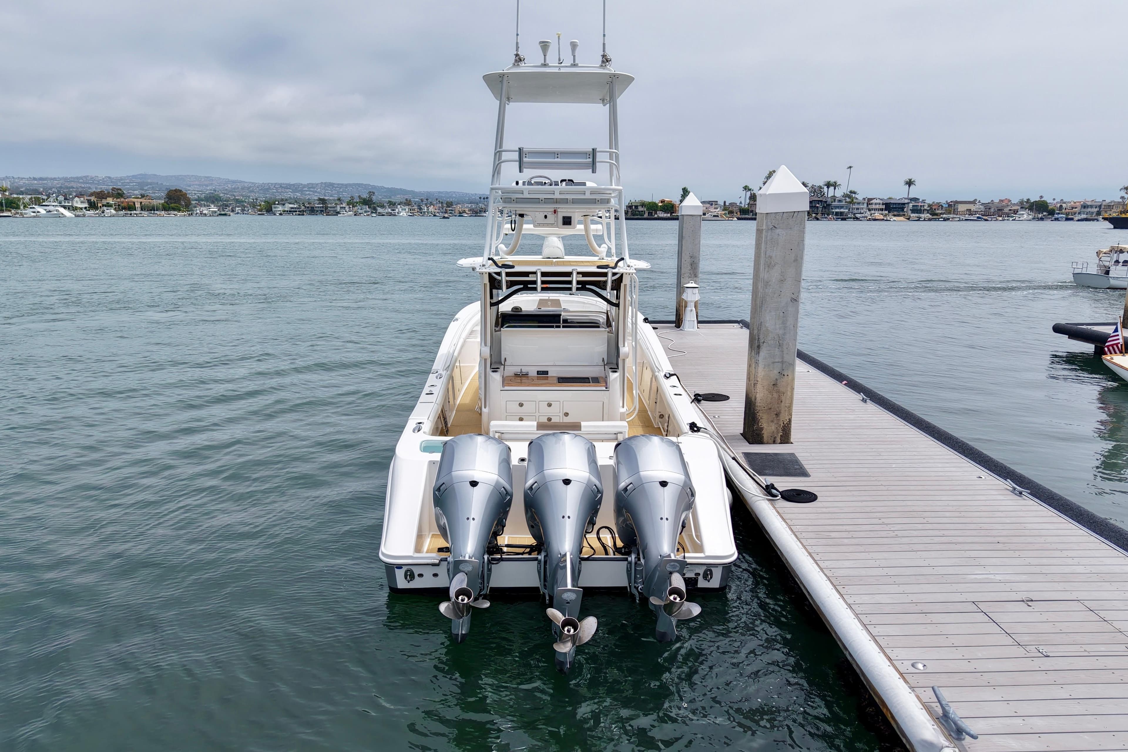 2016 Edgewater 368CC boat docked with triple outboard engines.