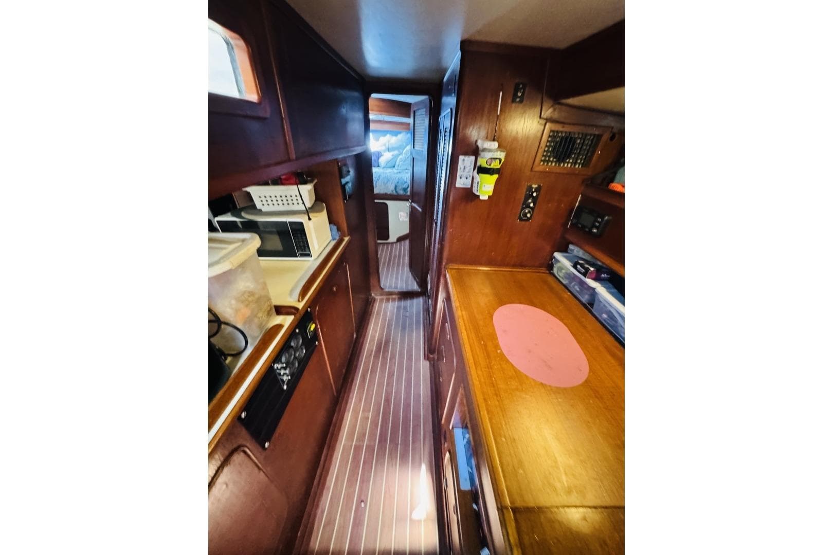 Interior of 1982 Irwin 41 CC Ketch sailboat, featuring a compact galley and wooden cabinetry.