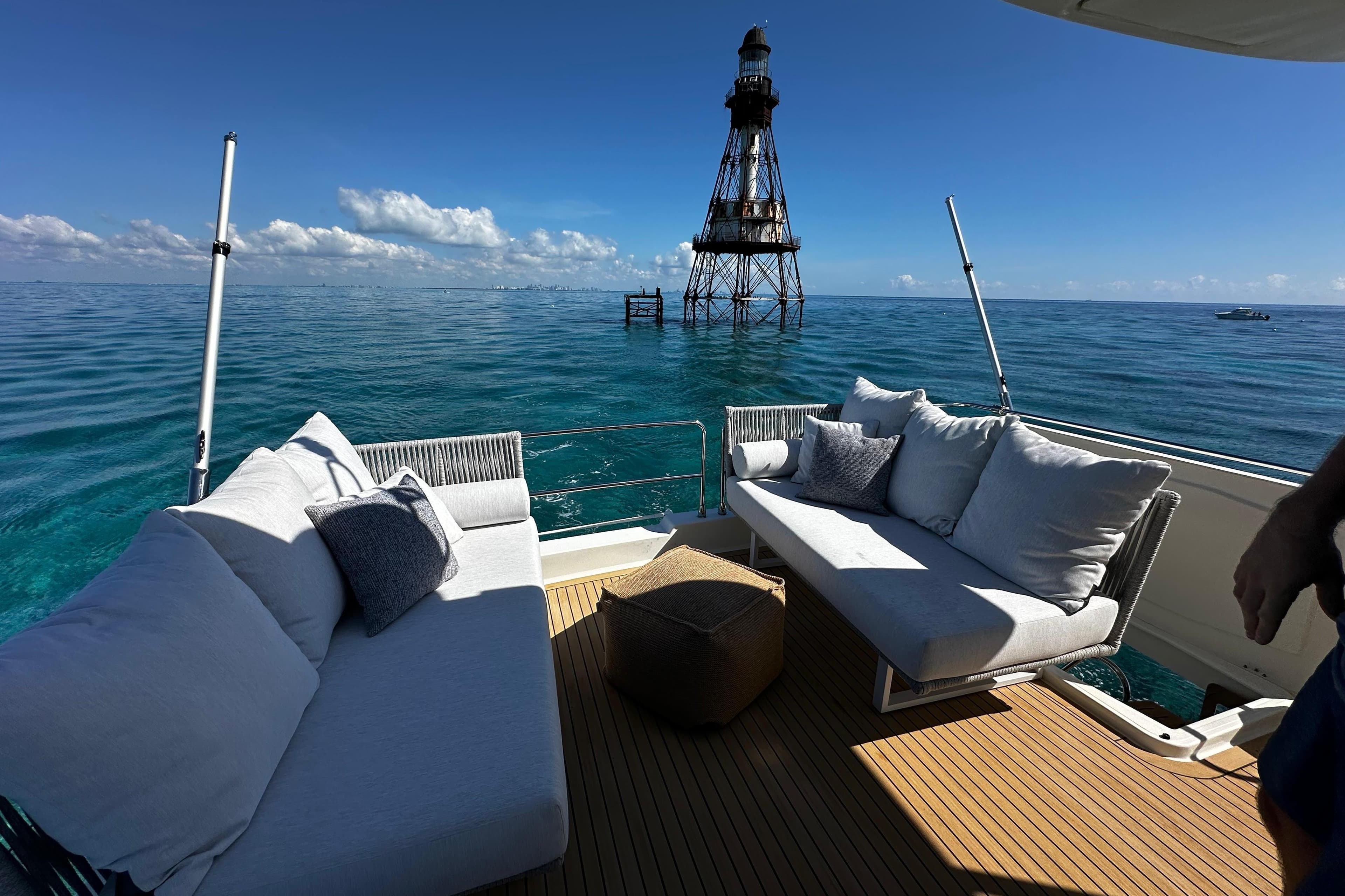 Luxurious deck of 2019 Beneteau Swift Trawler 47 with ocean view and lighthouse.