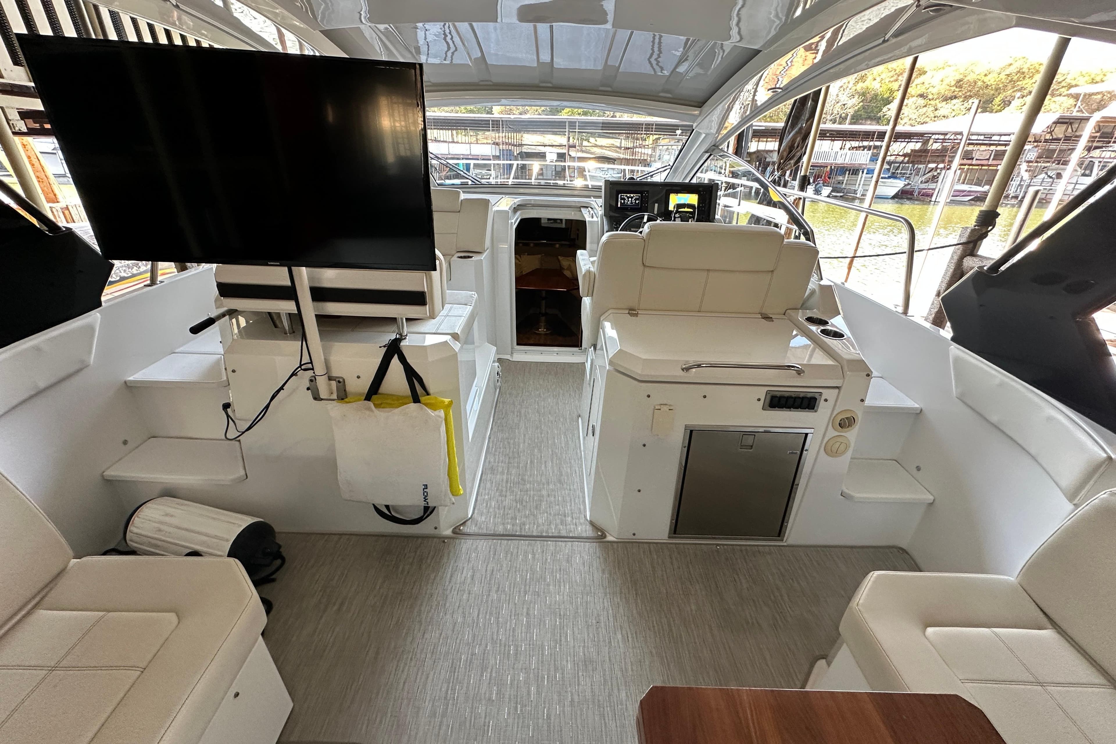 2021 Cruisers Yachts 390 Express Coupe interior with seating, TV, and helm.