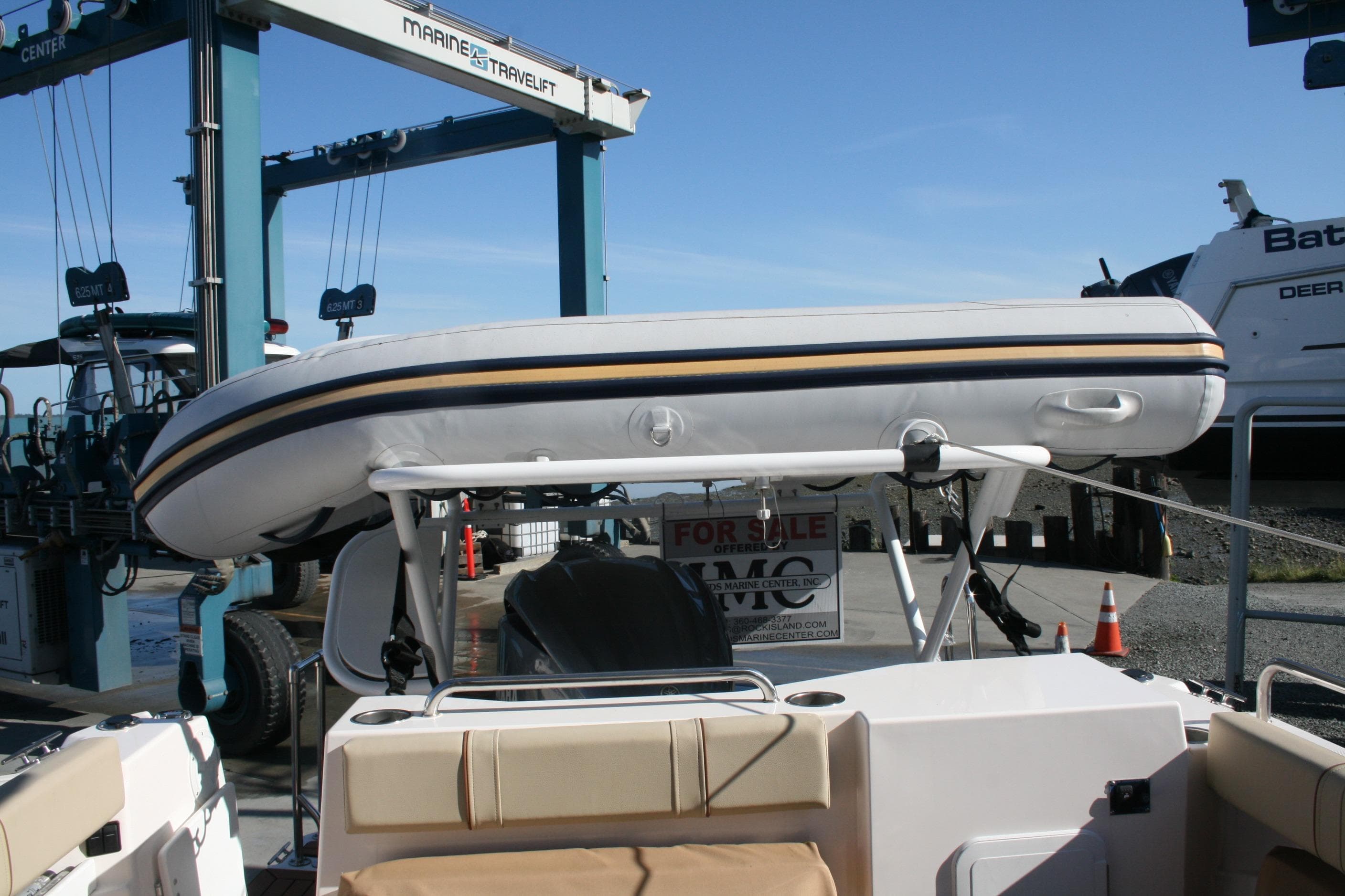 2024 Ranger Tugs R-25 with inflatable boat on deck at marina.