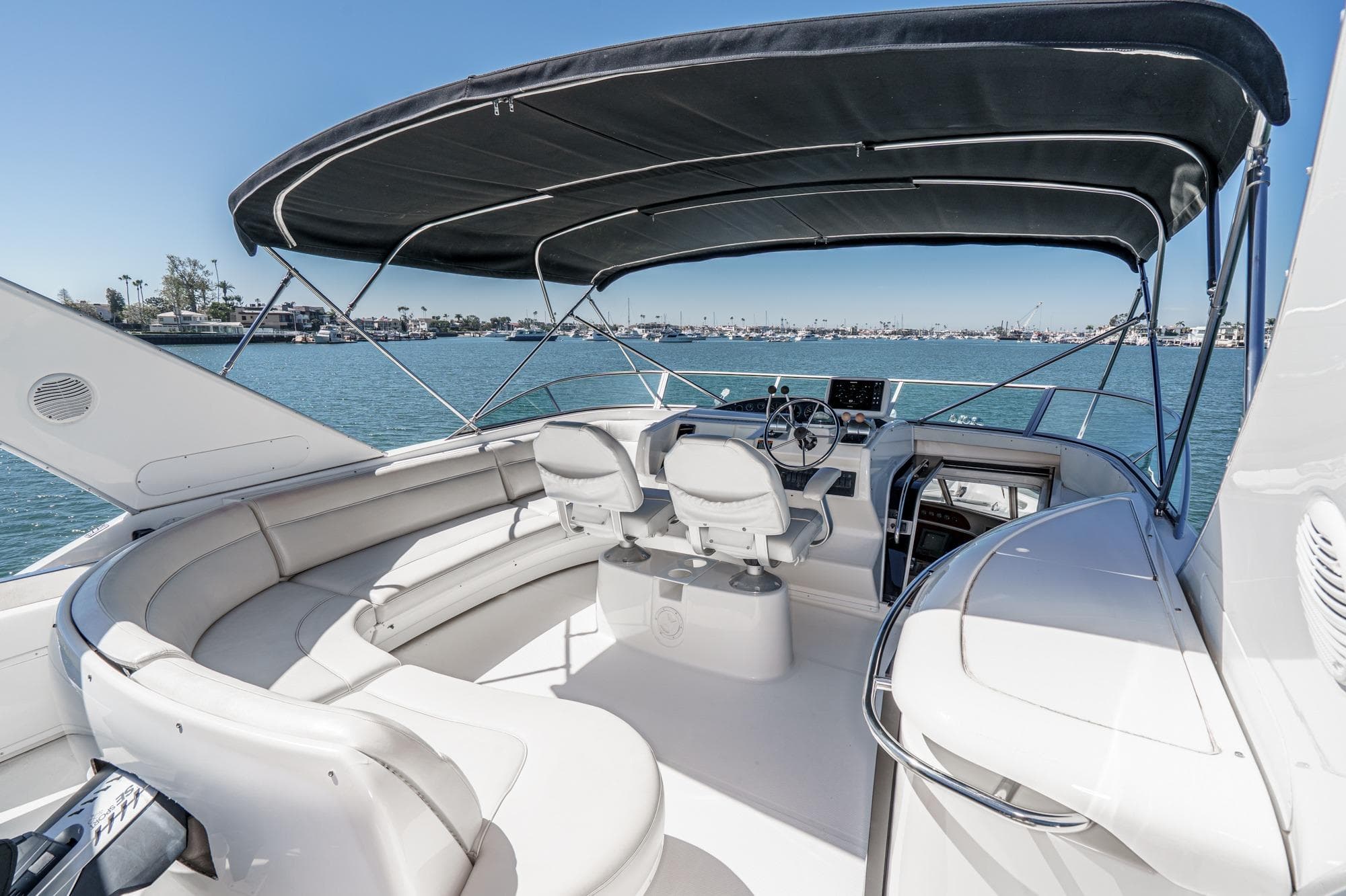 2000 Bayliner 5788 Pilot House Motoryacht cockpit with seating, helm, and canopy on water.