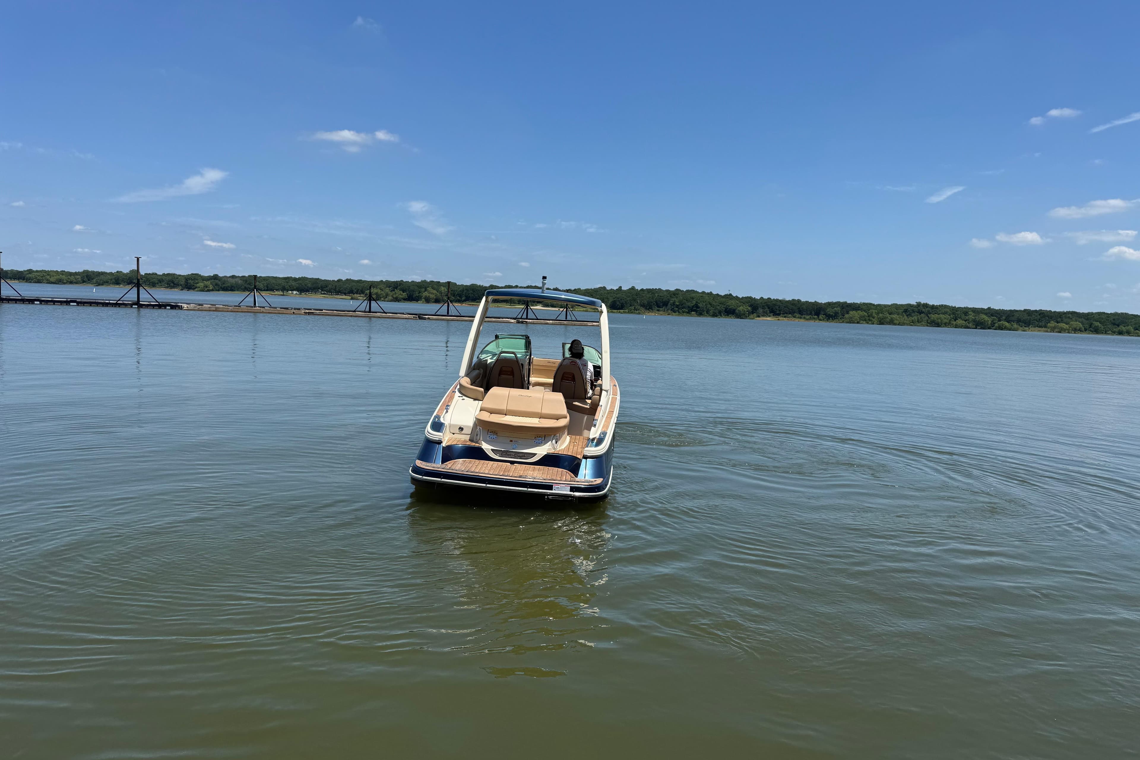 2022 Chris-Craft Launch 28 boat on calm lake under clear blue sky.