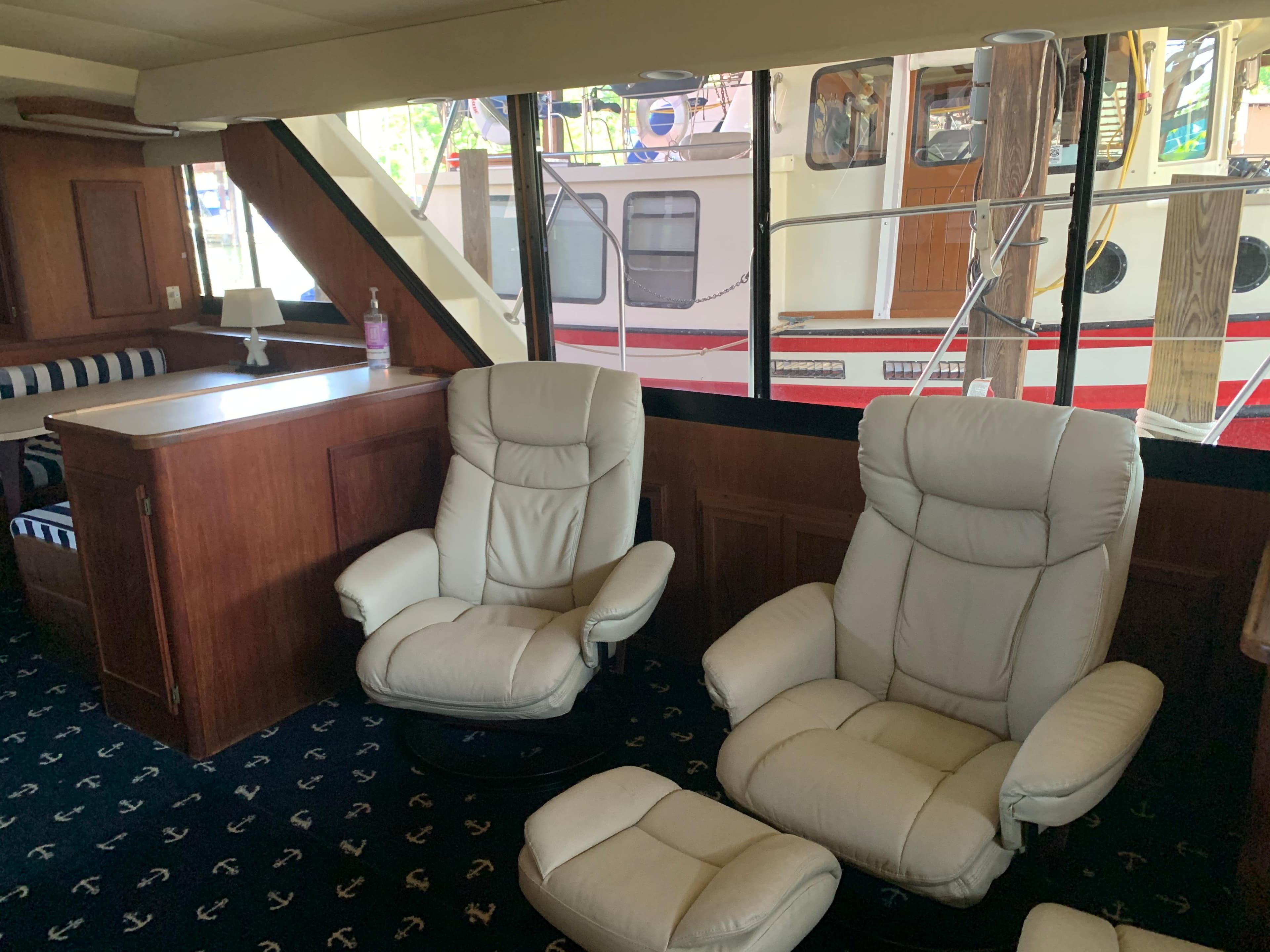Interior of 1988 Blue Water Coastal Cruiser with leather chairs and wooden cabinetry.