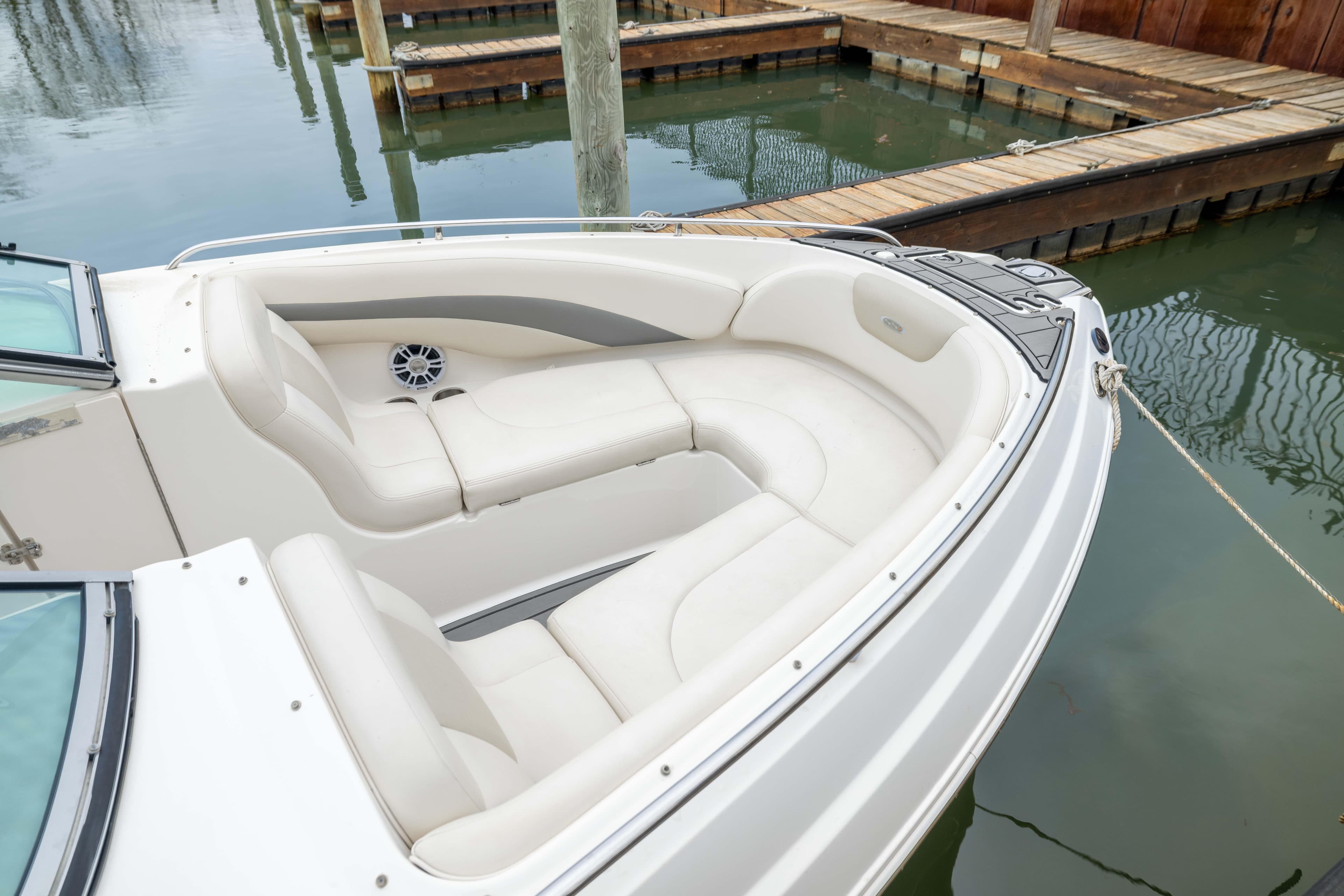 2008 Chaparral 256 SSi boat with white seating, docked at a marina.