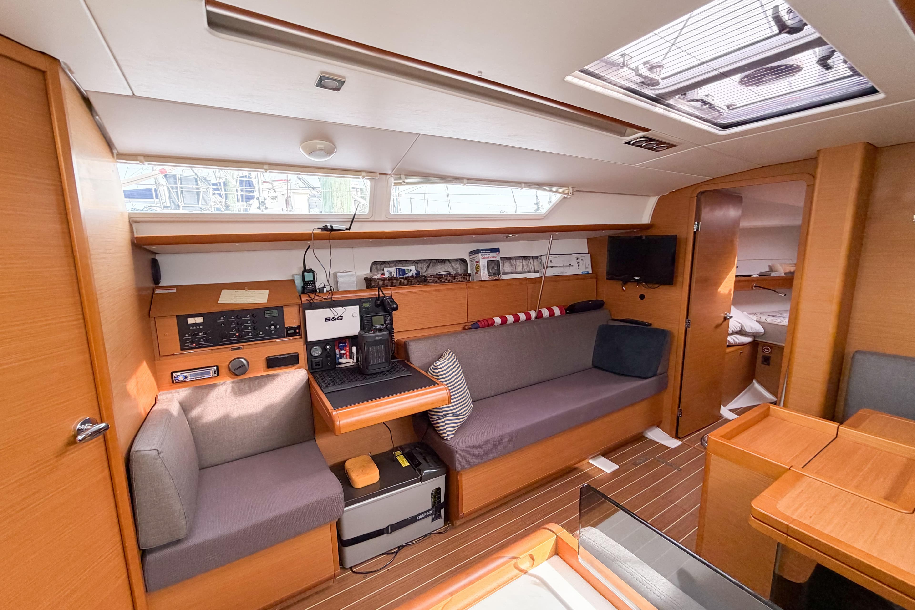 Interior of 2013 Jeanneau Sun Odyssey 409 sailboat, featuring cozy seating and navigation equipment.