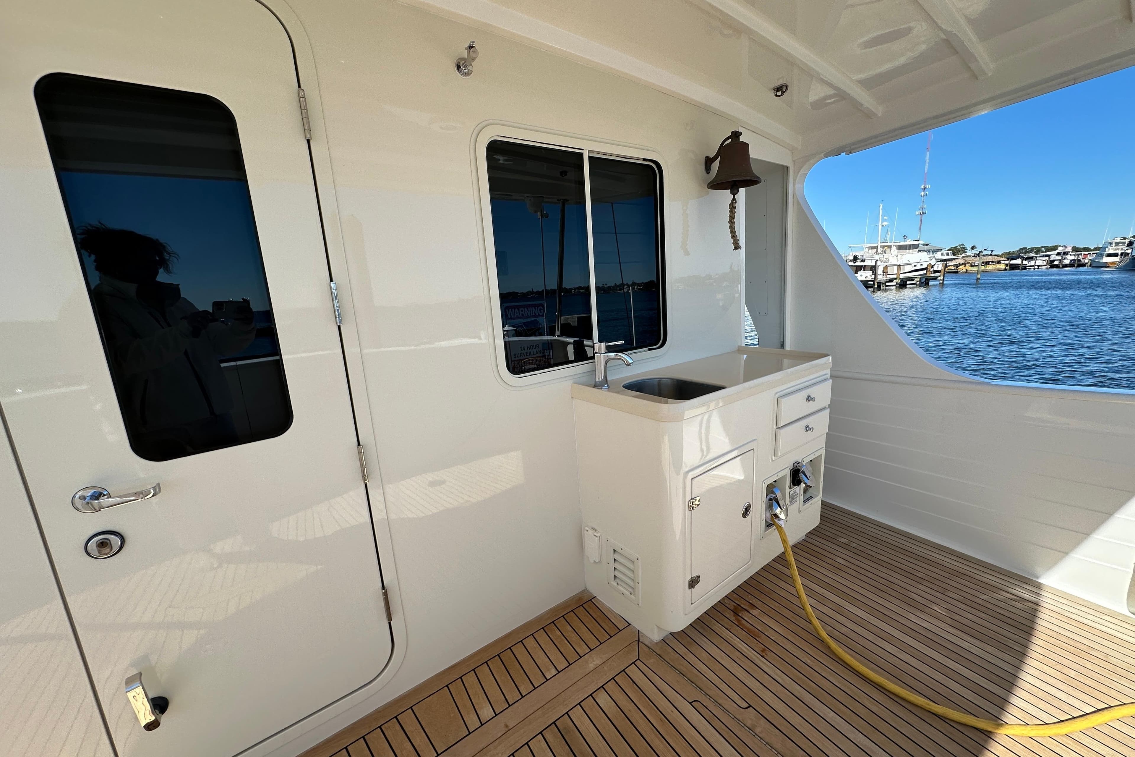 Kadey-Krogen 58EB 2017 yacht deck with sink, bell, and marina view.