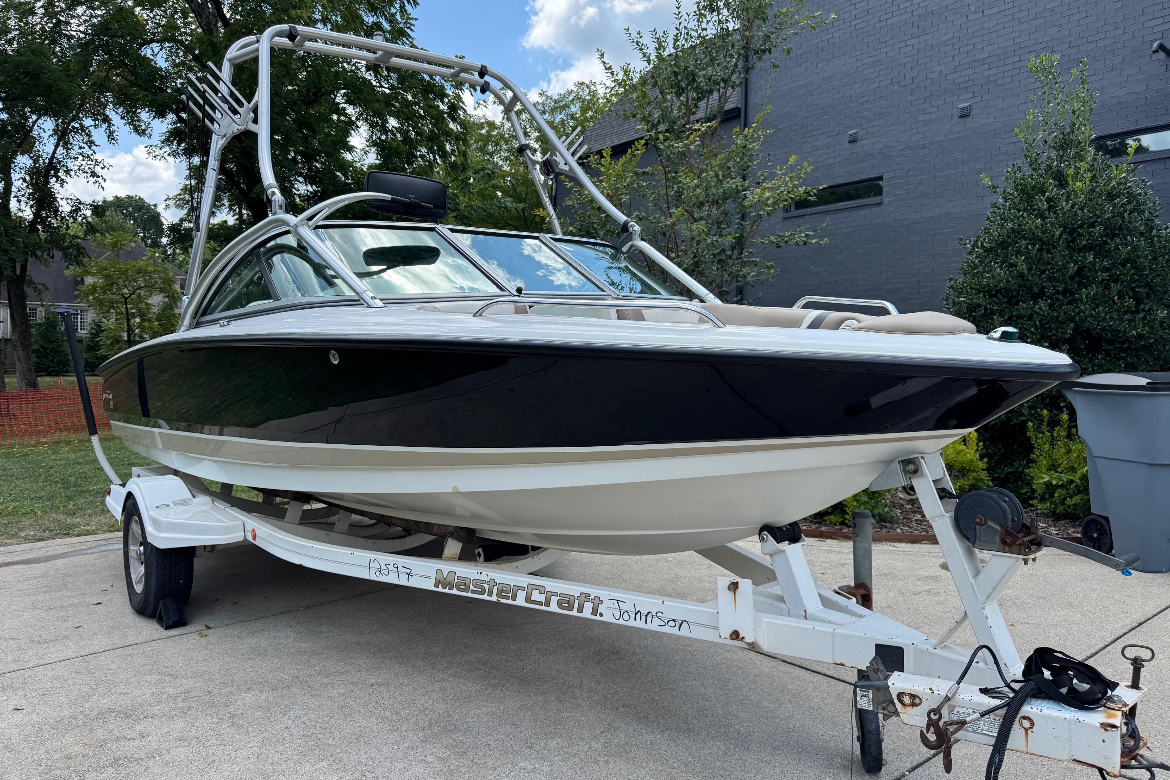 2002 MasterCraft ProStar 209 boat on trailer, parked outdoors.