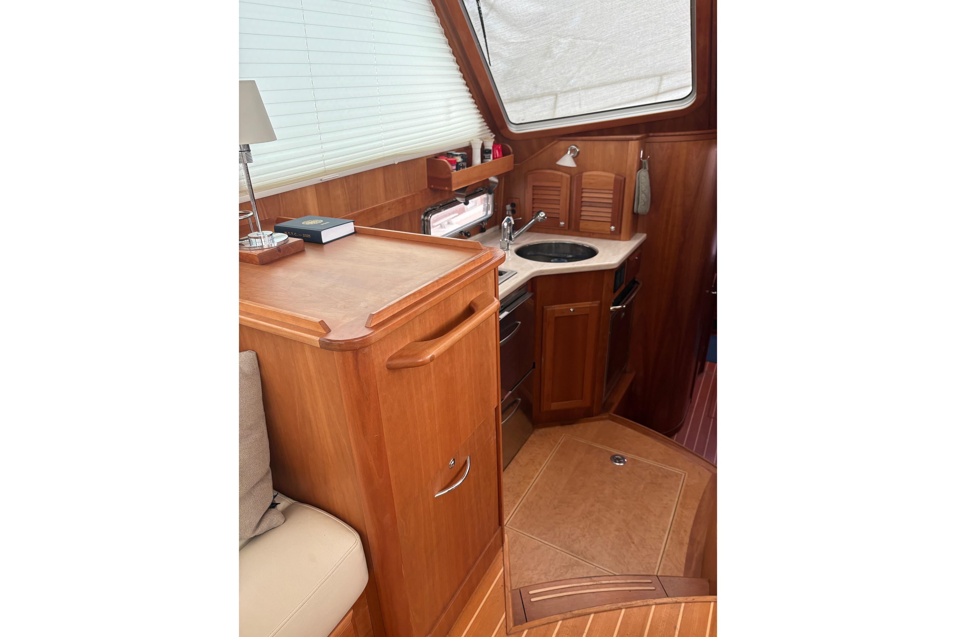 Interior of 2020 Sabre 42 Salon Express yacht with wooden cabinetry and compact kitchen.