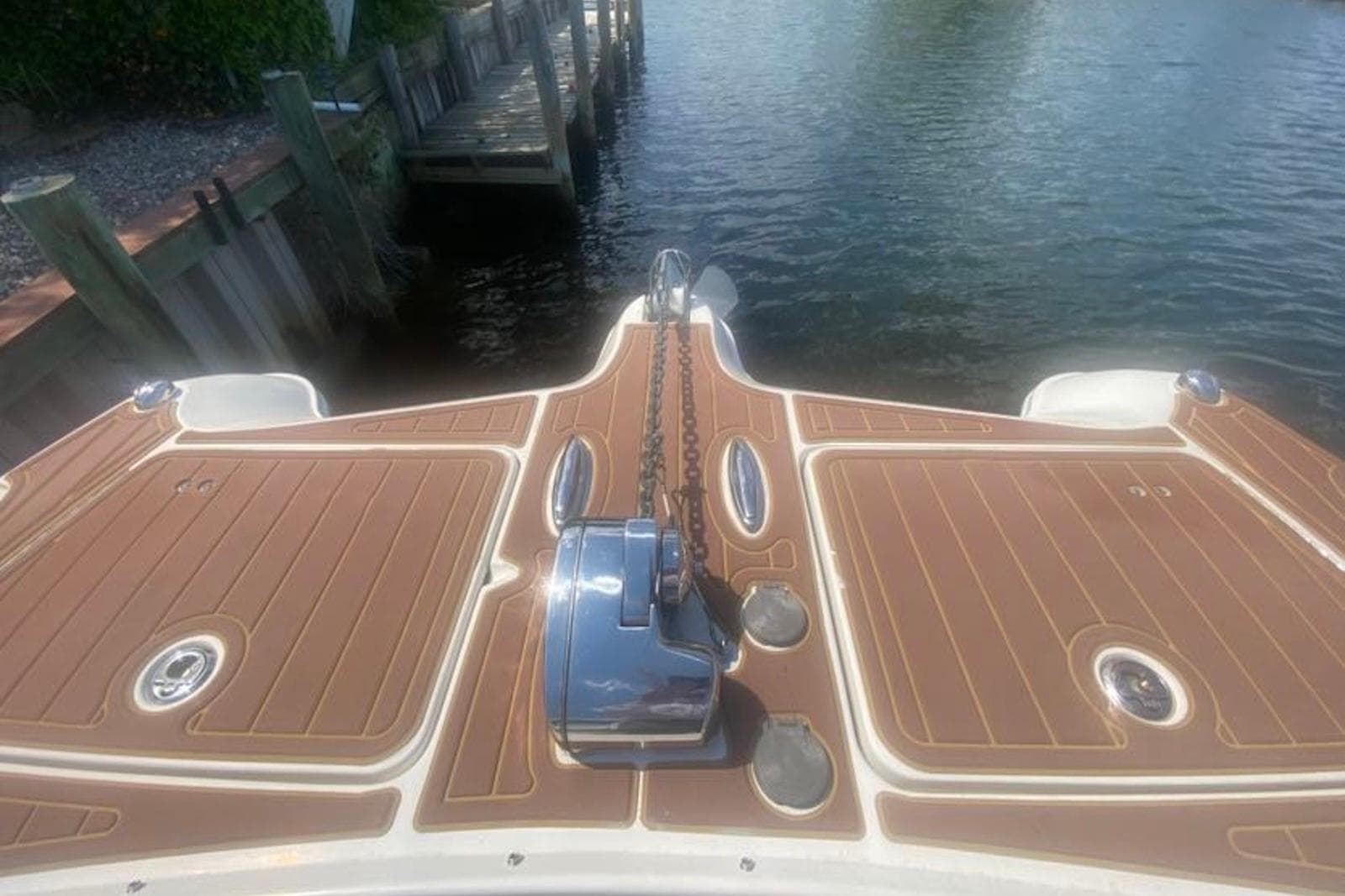 2017 World Cat 320 DC boat deck with anchor chain, docked by water.