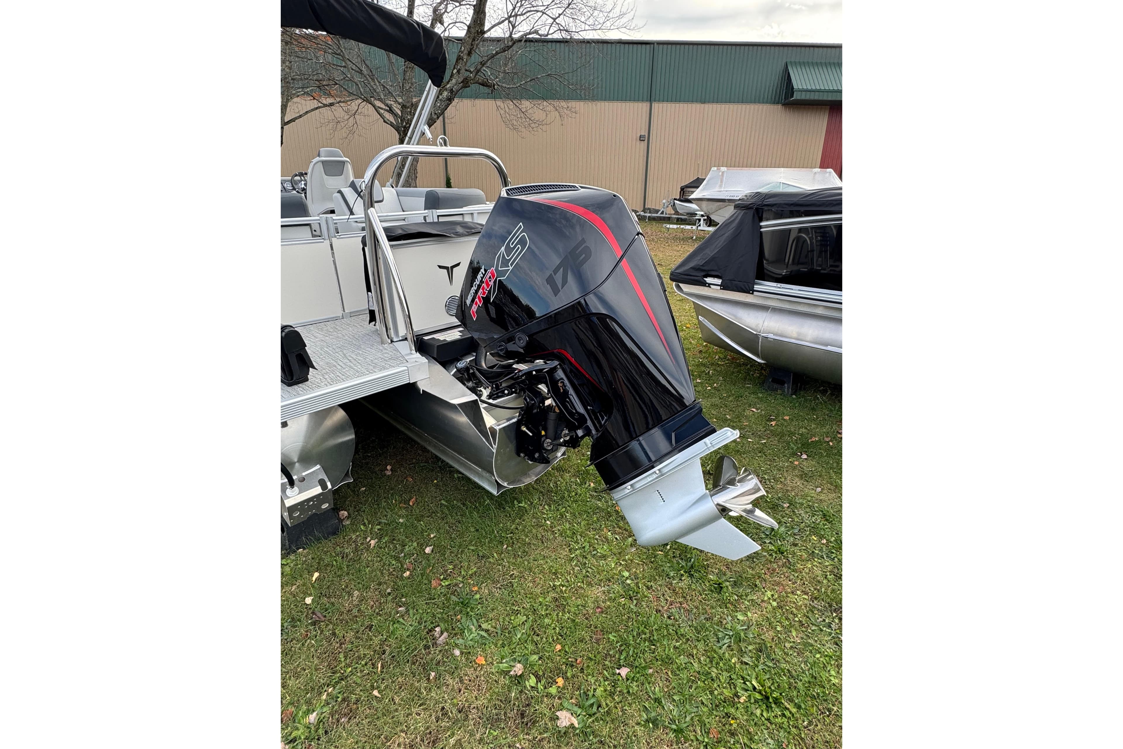 2026 Tahoe Pontoon LTZ Quad Lounger 23 with powerful outboard motor on grass.