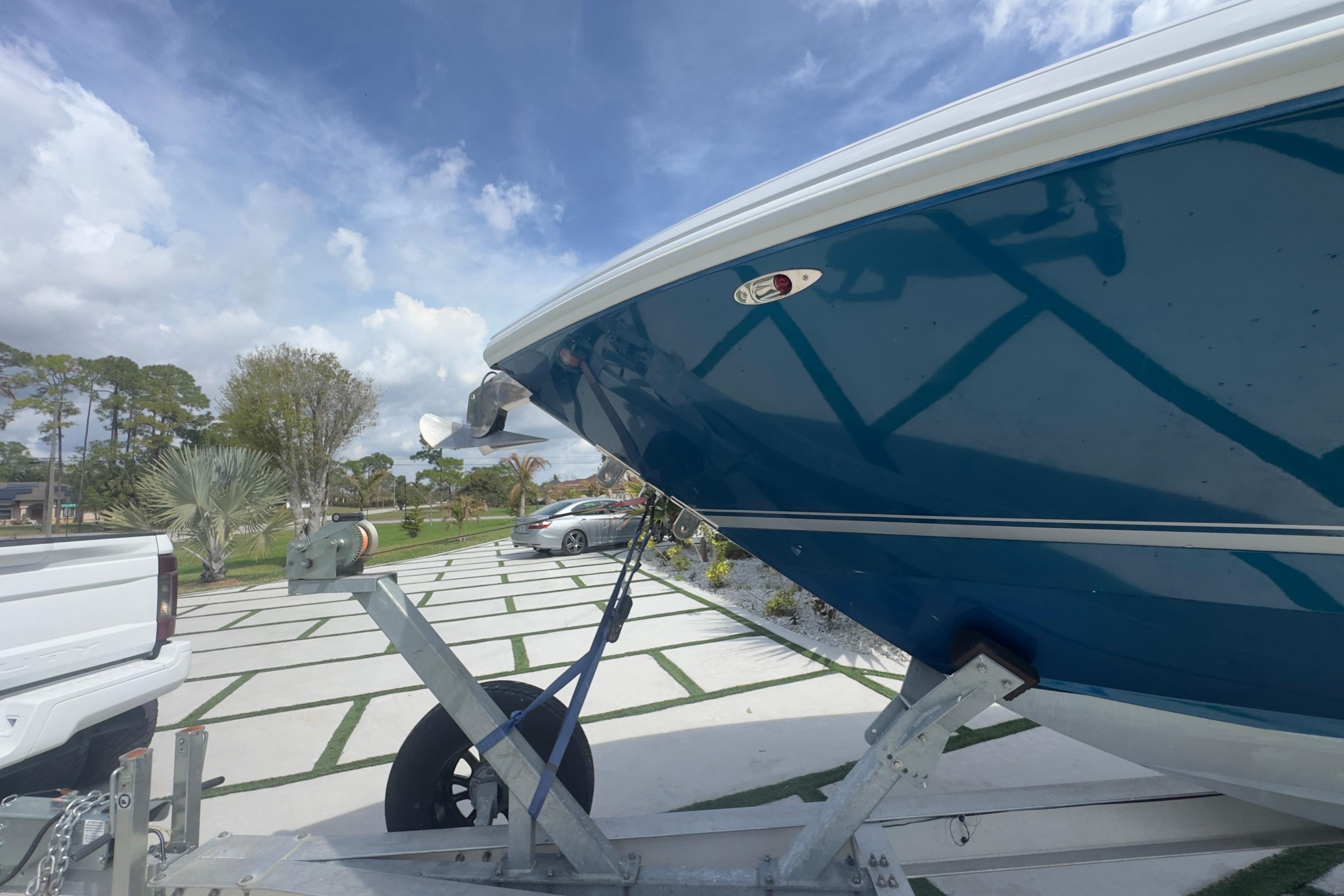 2007 Intrepid 370 Center Console boat on trailer, parked outdoors under a cloudy sky.