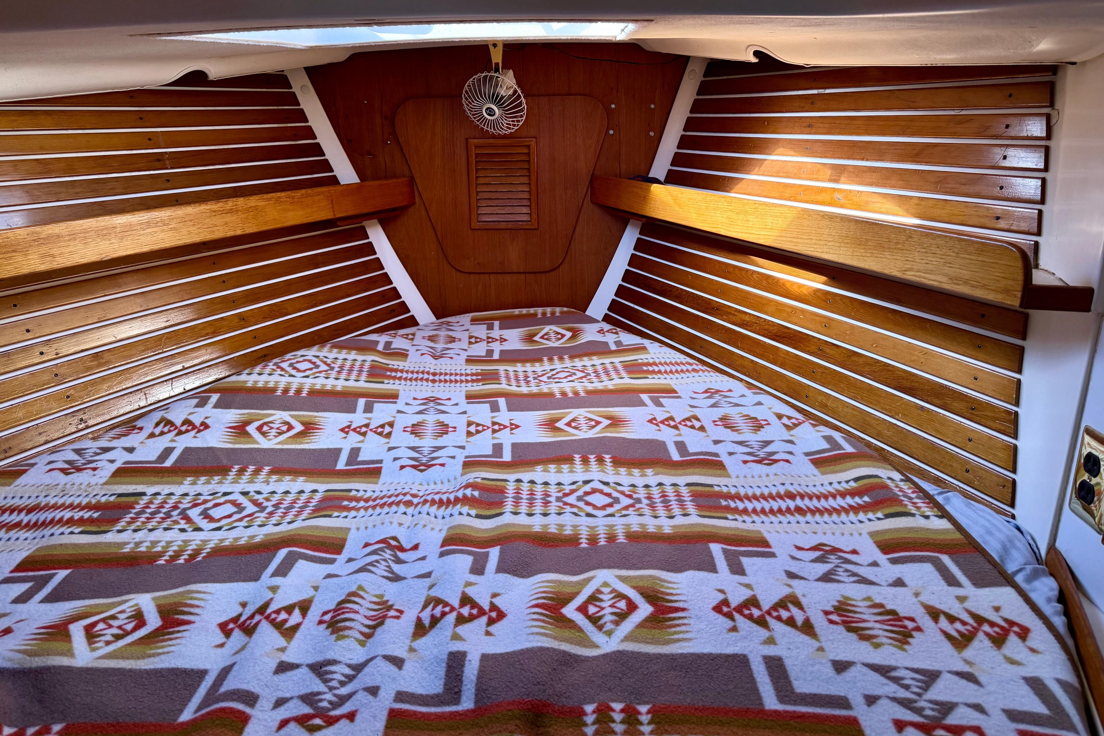1985 Niagara Encore boat cabin with patterned bedding and wooden interior.