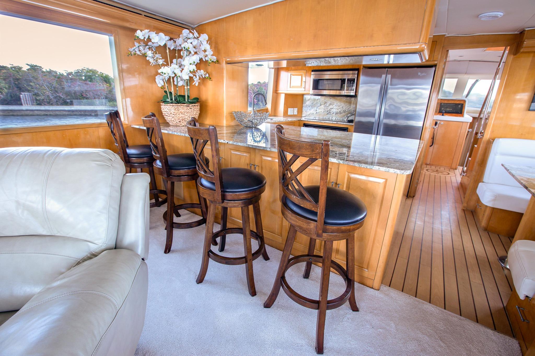 Luxurious interior of 2001 Hatteras 75 Cockpit Motor Yacht with elegant bar seating.