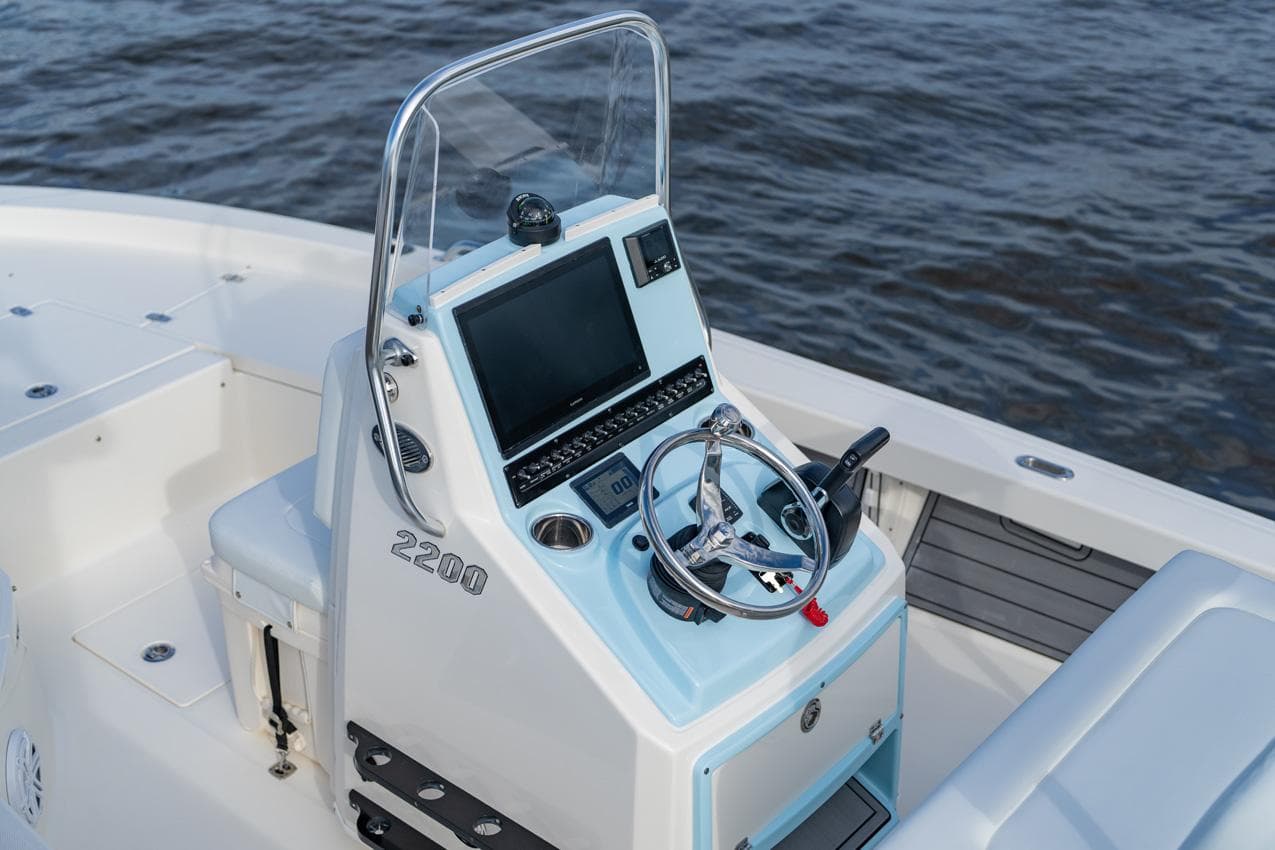 Manufacturer Provided Image: 2026 Pathfinder 2200 TRS boat console with steering wheel and navigation screen on water.