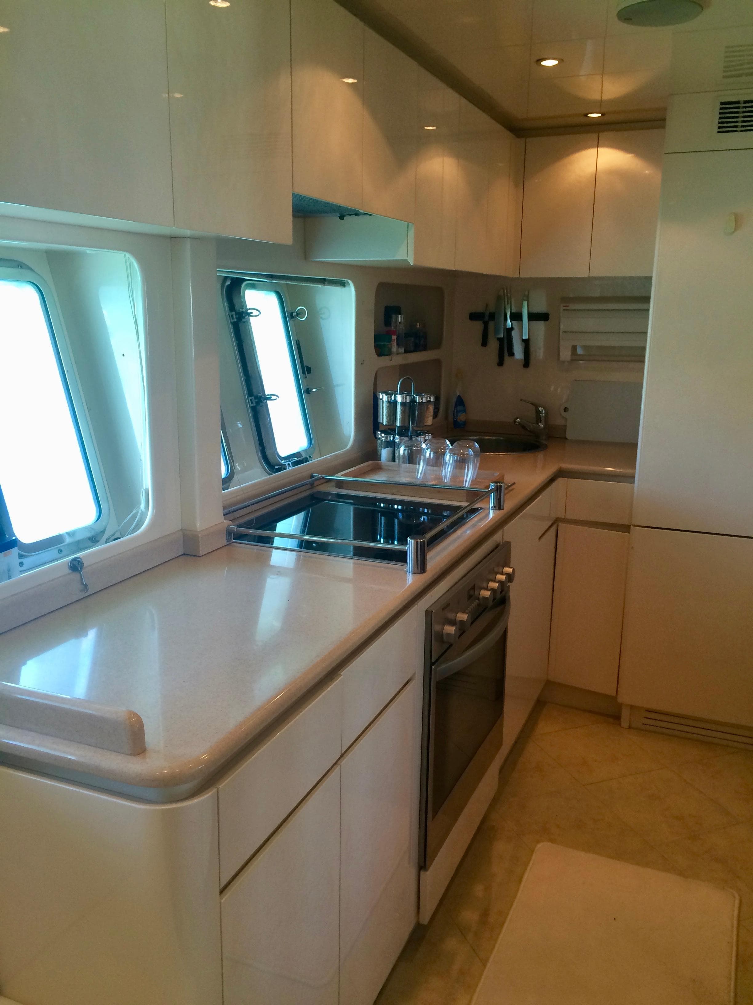 Luxurious kitchen interior of 2002 Mangusta 72 yacht with modern appliances and sleek design.