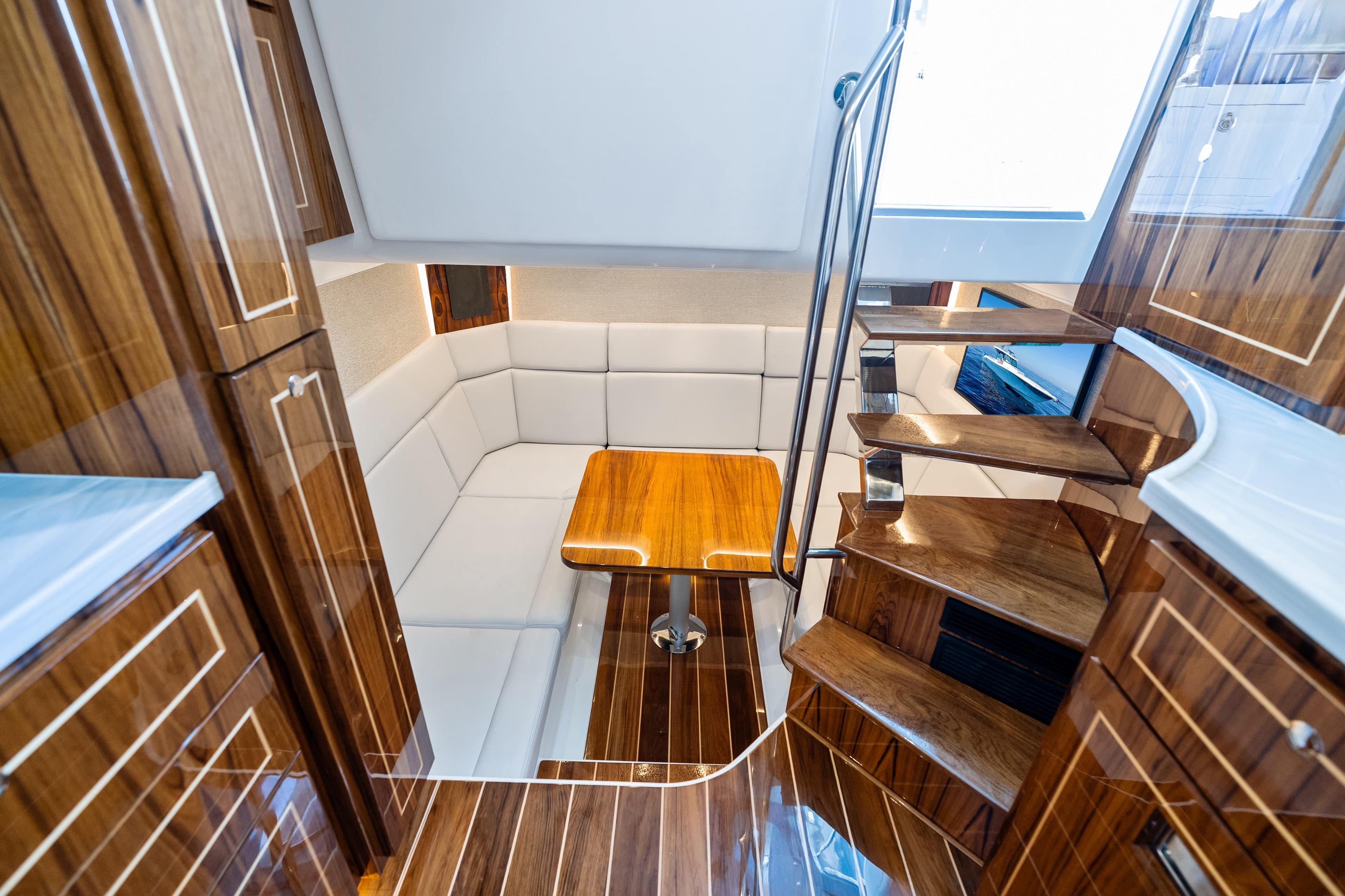 Luxurious interior of 2025 HCB 56 Suenos GIX yacht with wooden finishes and seating area.